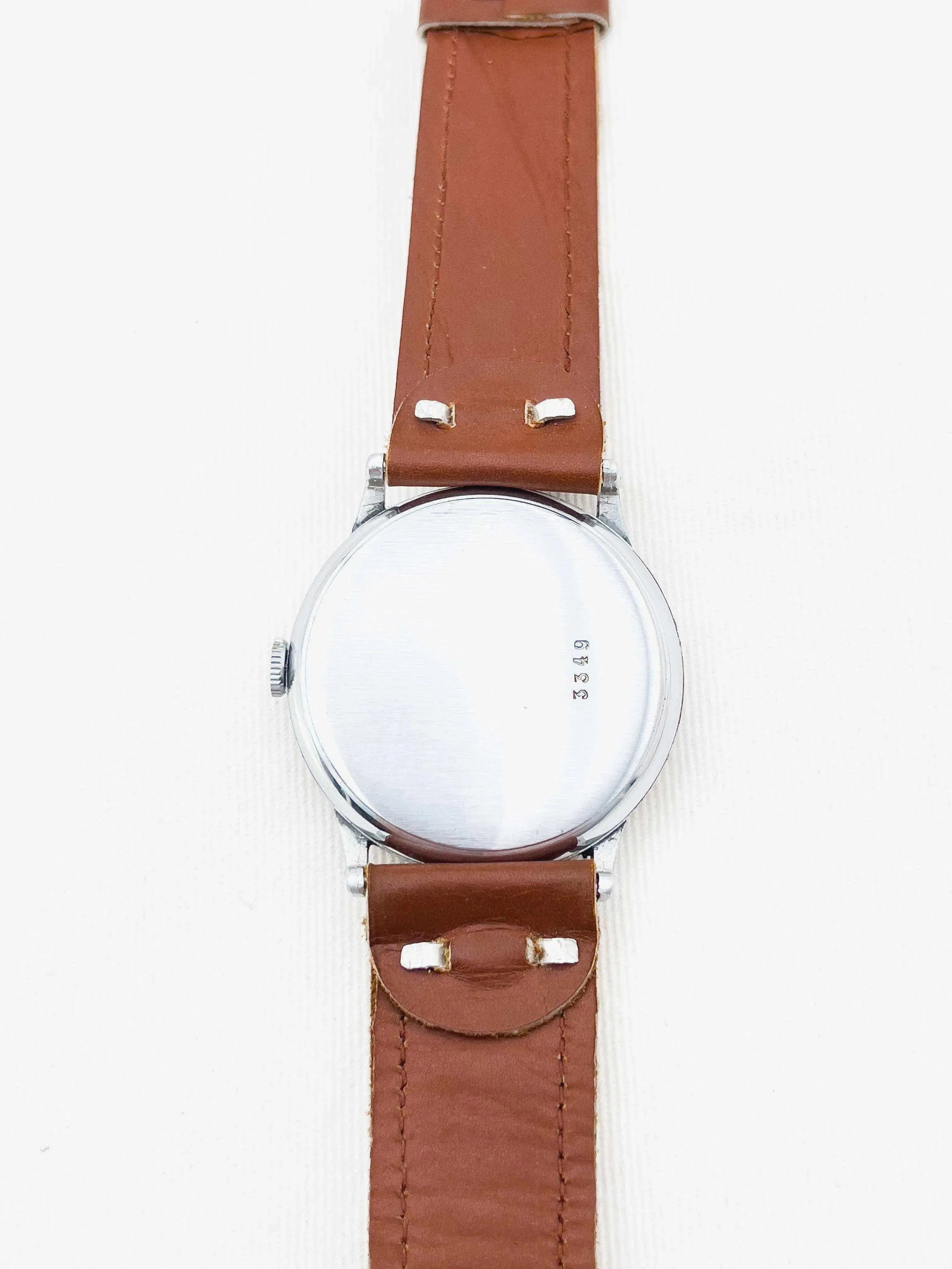 Vintage watch with stainless steel case, brown leather strap, back view on white background