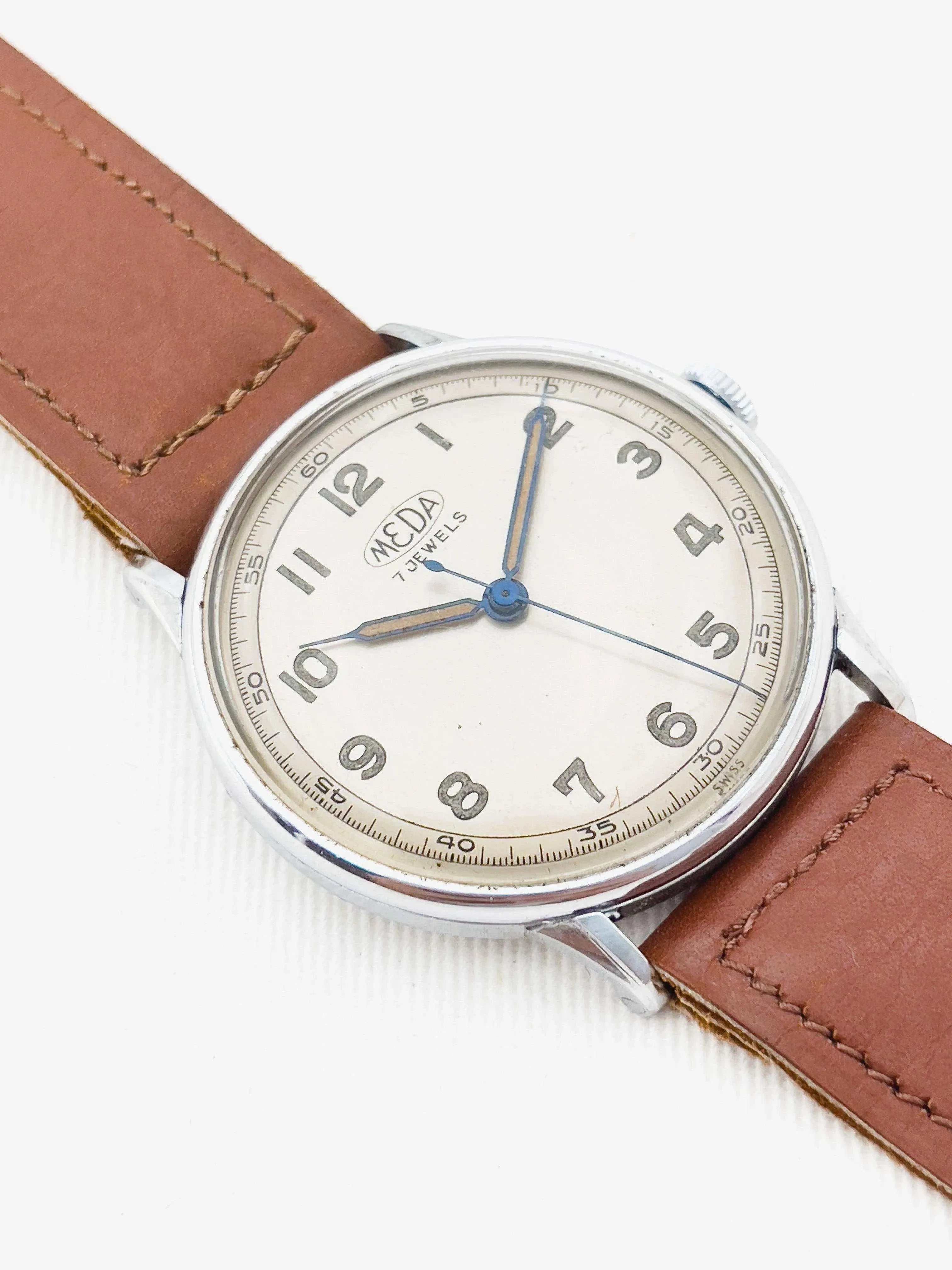 Meda vintage watch with cream dial, blue hands, and brown leather strap