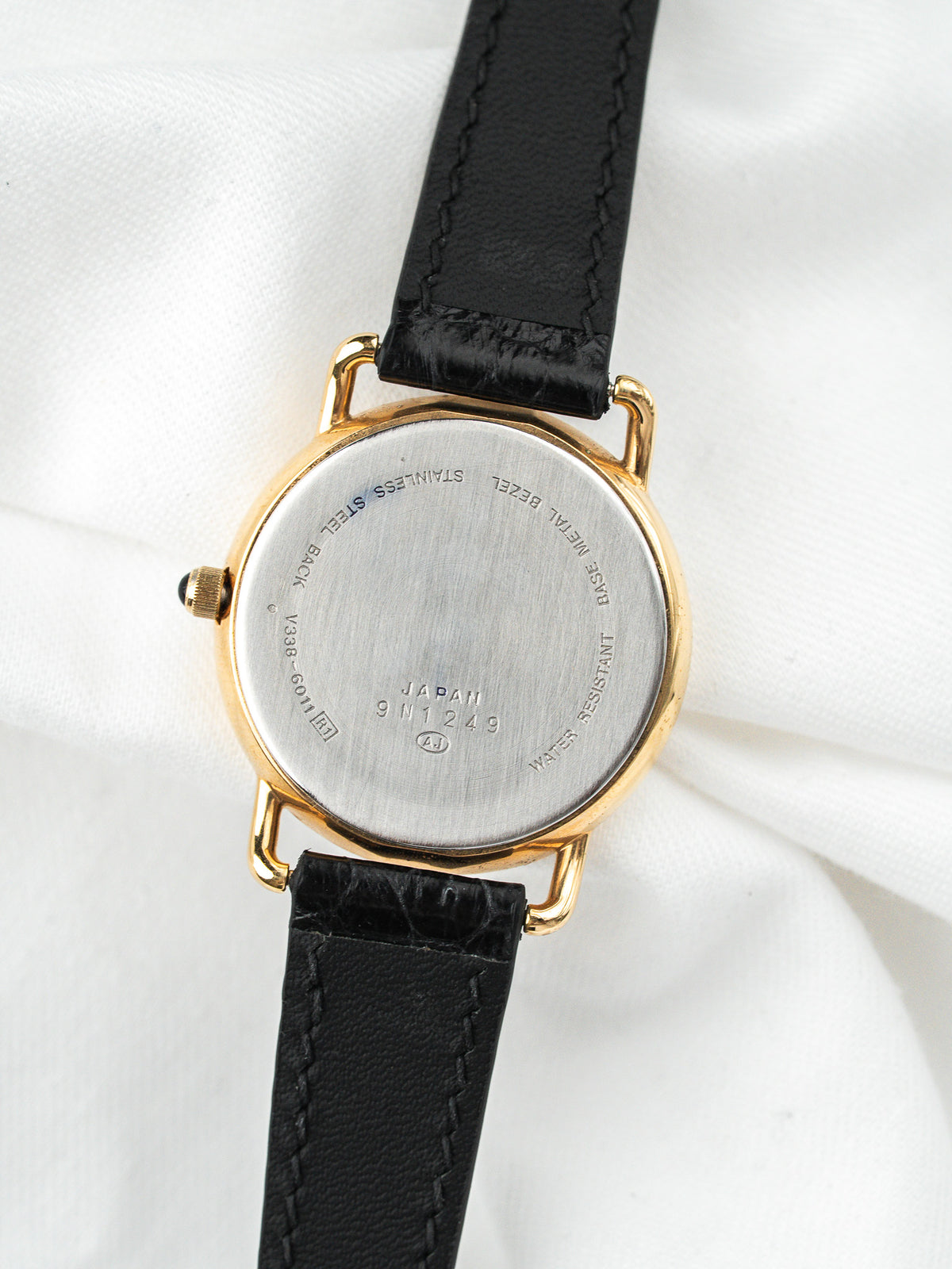 Dos de montre vintage en acier et or avec bracelet en cuir noir