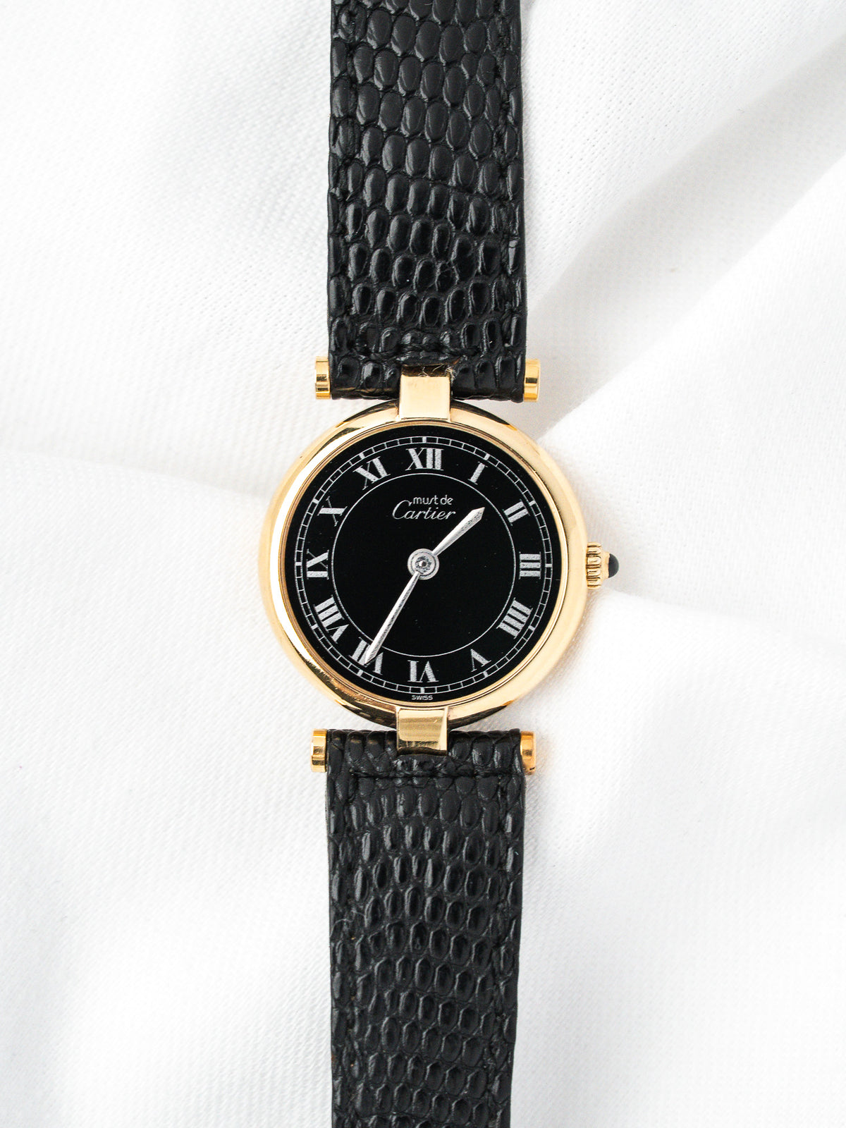Cartier Must de Cartier watch with gold case, black dial, and textured strap