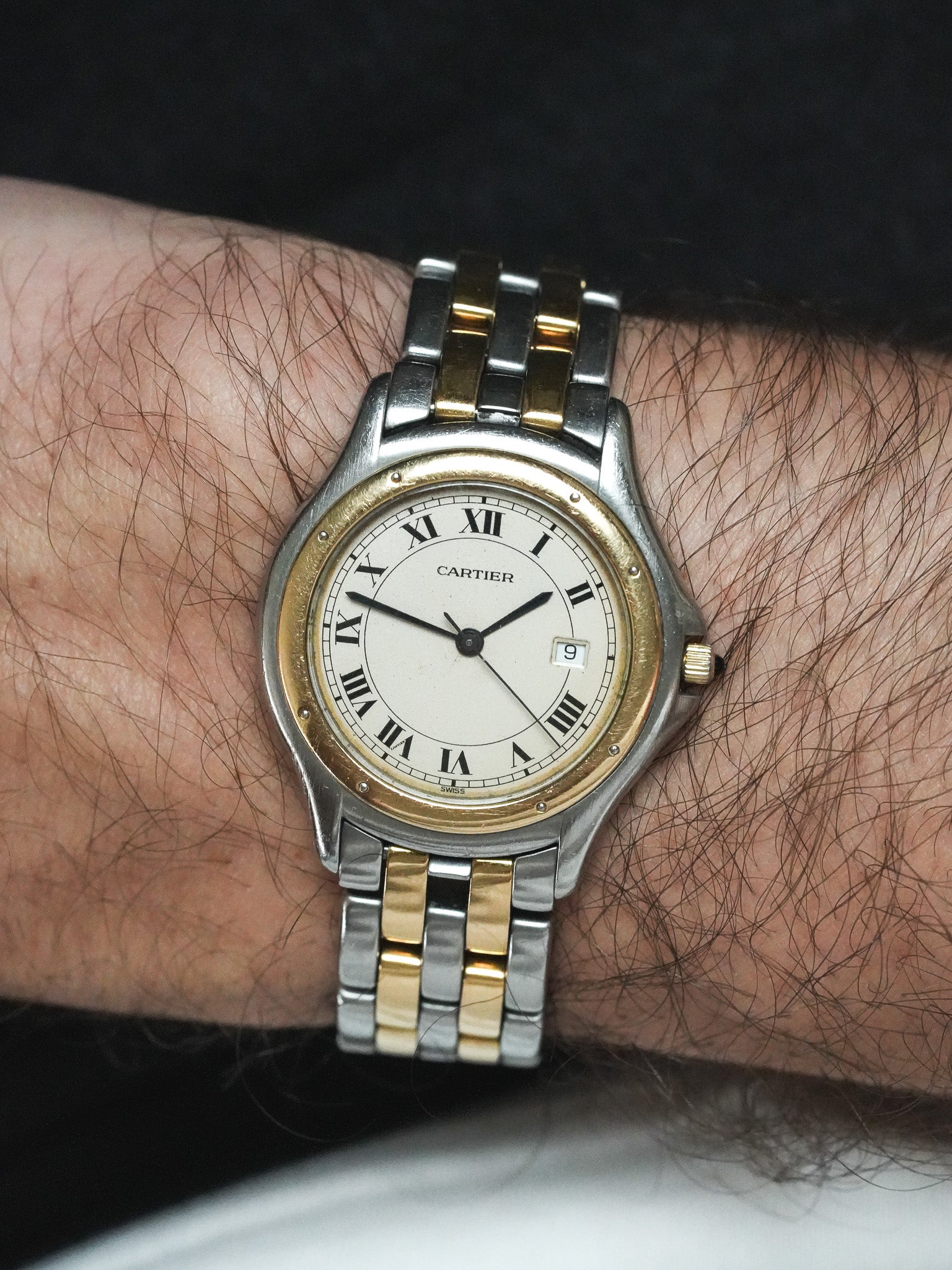 Cartier vintage watch with two-tone steel and gold bracelet, white dial, Roman numerals, worn on wrist