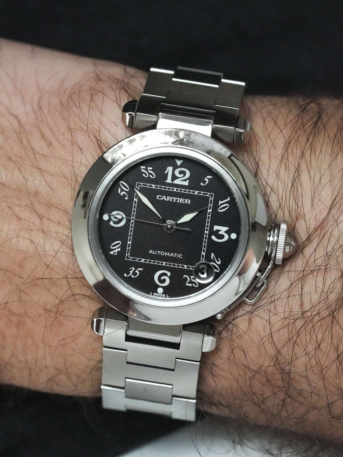 Cartier Pasha automatic watch with black dial and steel bracelet worn on wrist