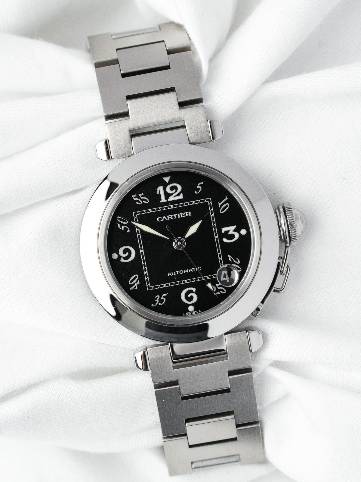 Cartier Pasha automatic watch with black dial, steel case and bracelet on white fabric