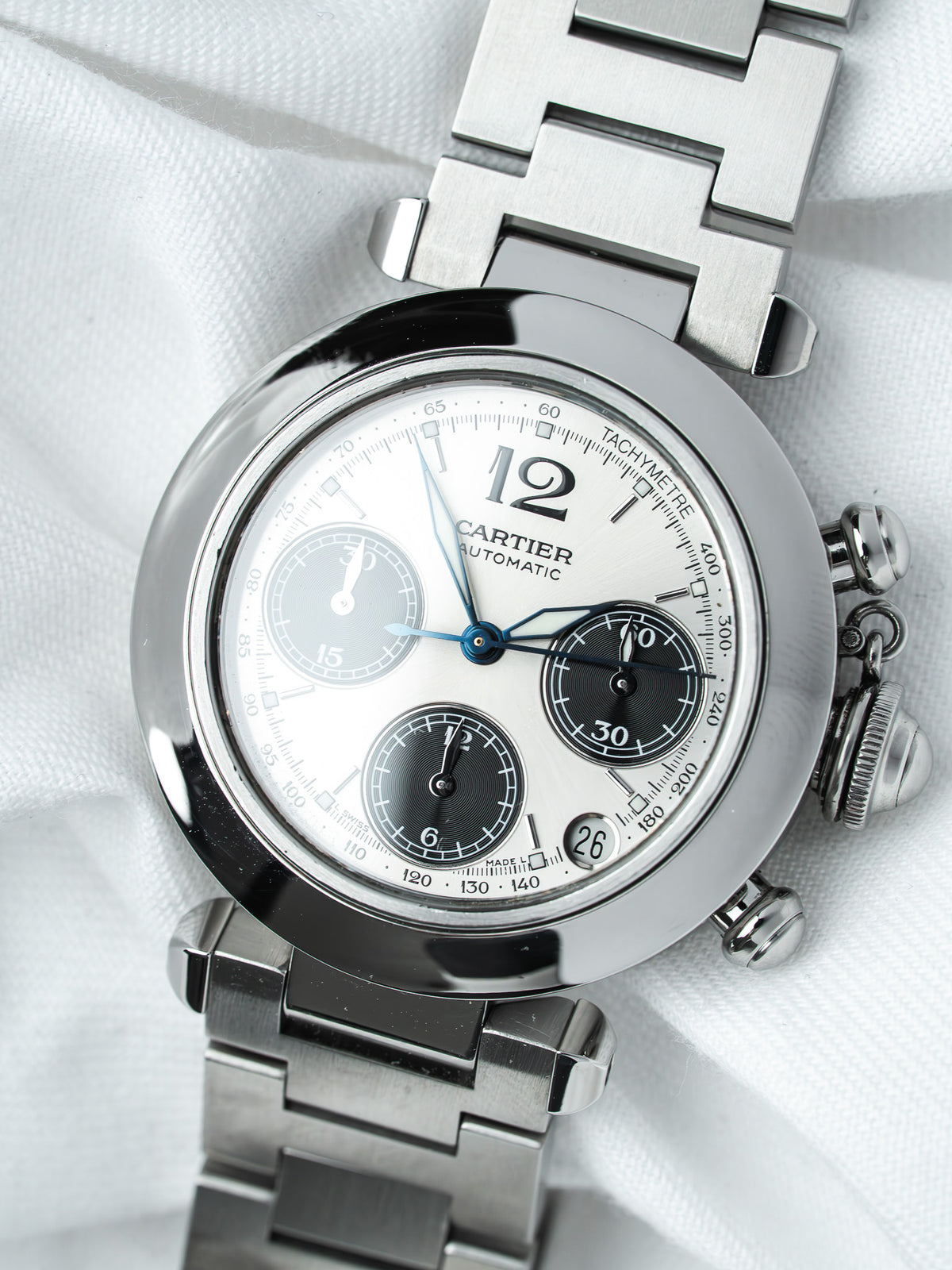 Cartier chronograph watch with white dial, steel bracelet, and tachymeter bezel