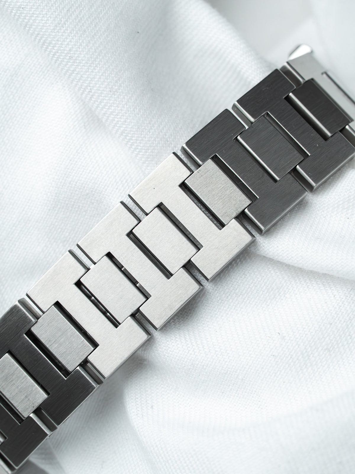 Vintage Rolex Oyster bracelet in brushed stainless steel, laid on white fabric