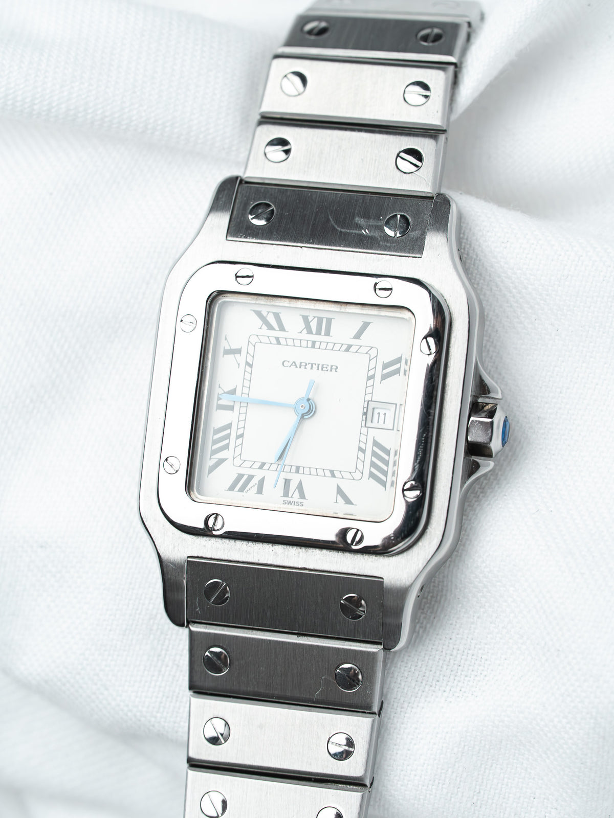 Cartier Santos watch with white dial, Roman numerals, and steel bracelet