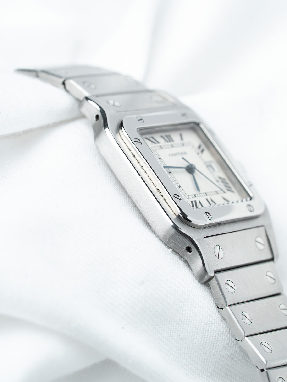 Cartier Santos watch with steel bracelet, white dial, Roman numerals on soft fabric