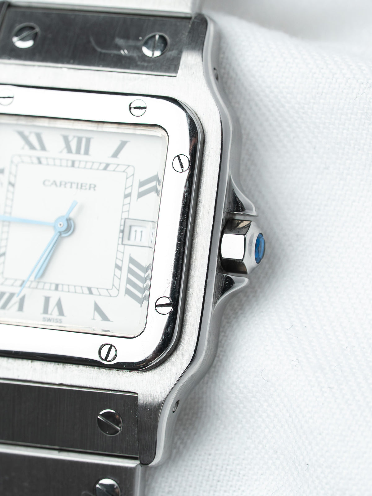 Cartier Santos watch with white dial, blue hands, and steel case