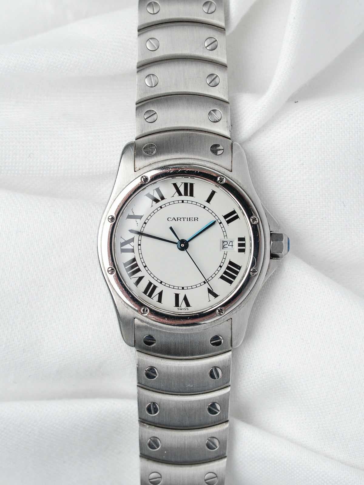 Cartier Santos watch with white dial, Roman numerals, steel bracelet on white fabric