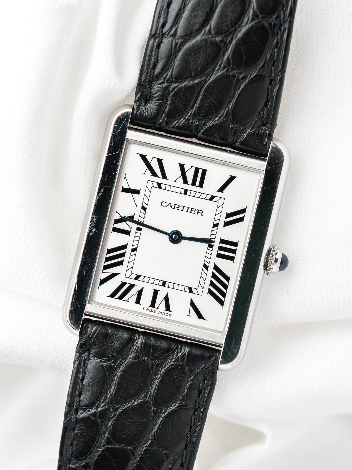 Montre Cartier Tank vintage, boîtier rectangulaire argenté, cadran blanc et bracelet cuir noir