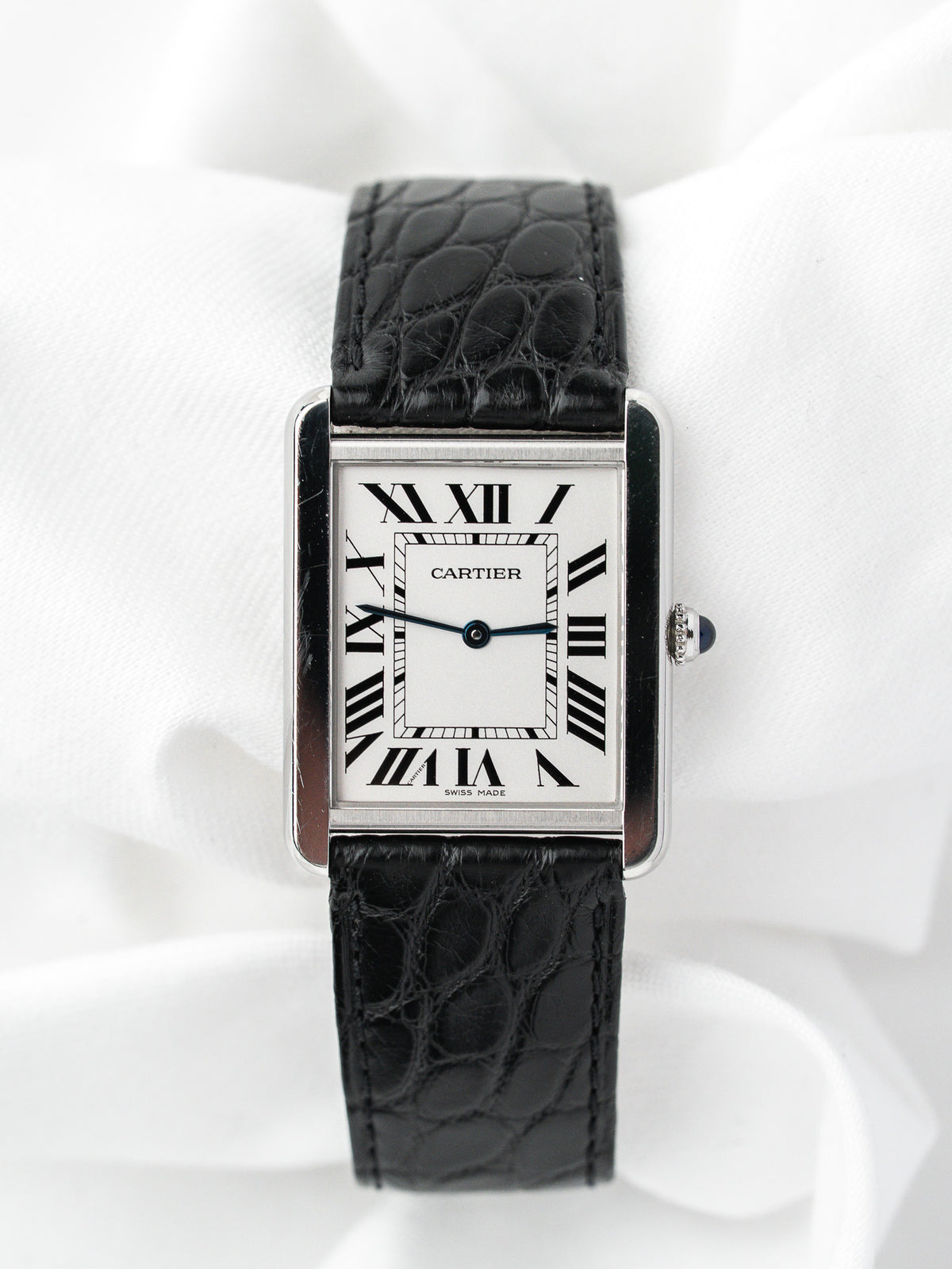 Montre Cartier Tank vintage, boîtier rectangulaire argenté, cadran blanc et bracelet cuir noir
