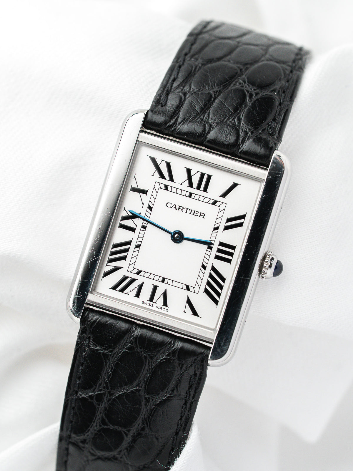 Montre Cartier Tank vintage, boîtier rectangulaire acier, cadran blanc et bracelet cuir noir