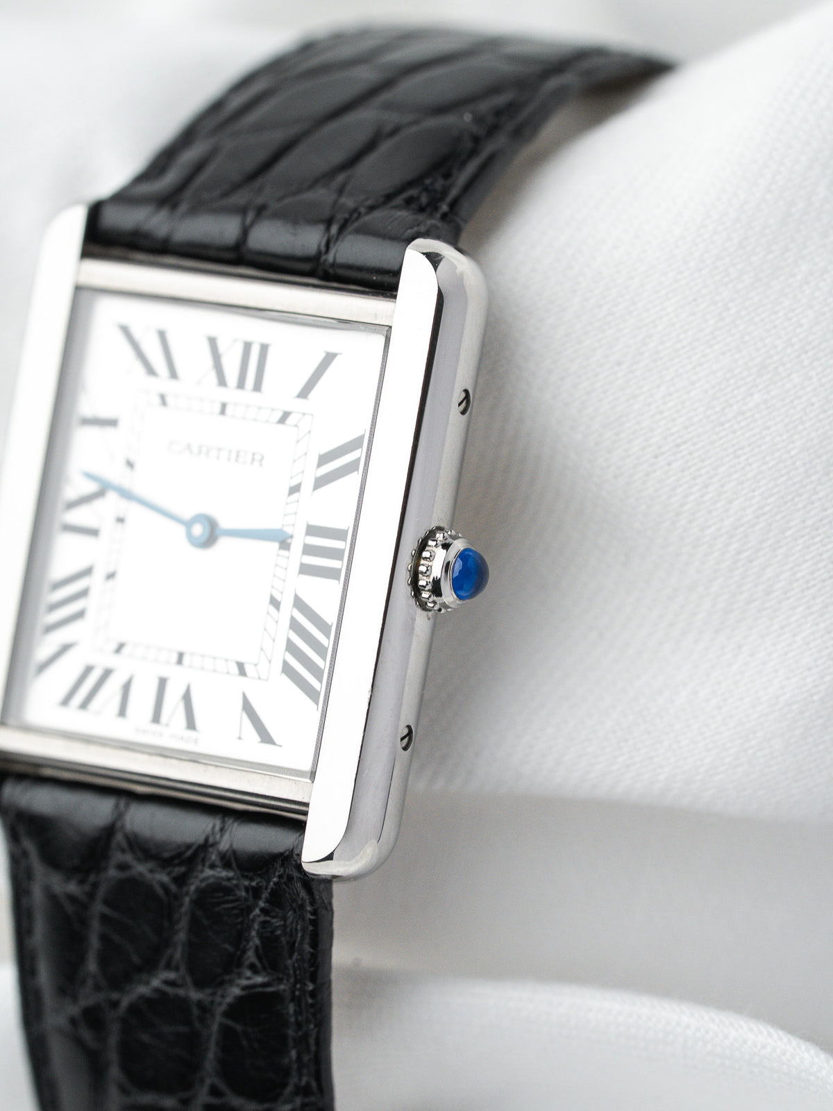 Montre Cartier Tank vintage, boîtier rectangulaire argenté, cadran blanc et bracelet cuir noir