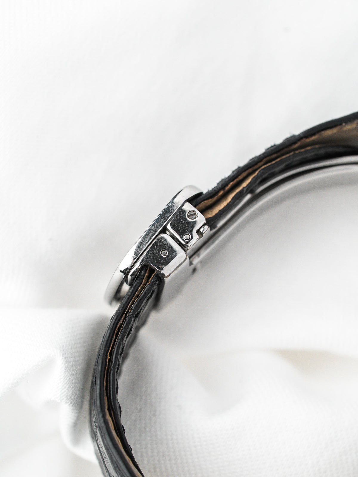Détail du boîtier en acier et du bracelet en cuir noir d'une montre vintage
