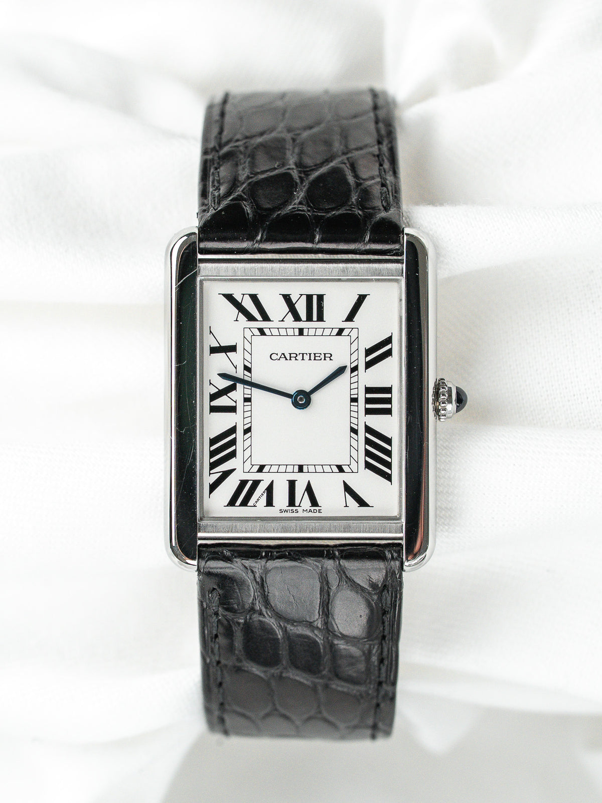 Montre Cartier Tank vintage, boîtier rectangulaire argenté, cadran blanc et bracelet cuir noir