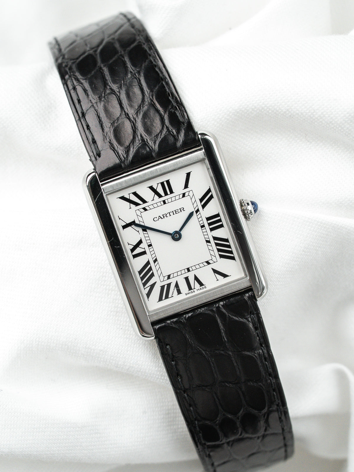 Montre Cartier Tank vintage, boîtier rectangulaire argenté, cadran blanc et bracelet cuir noir