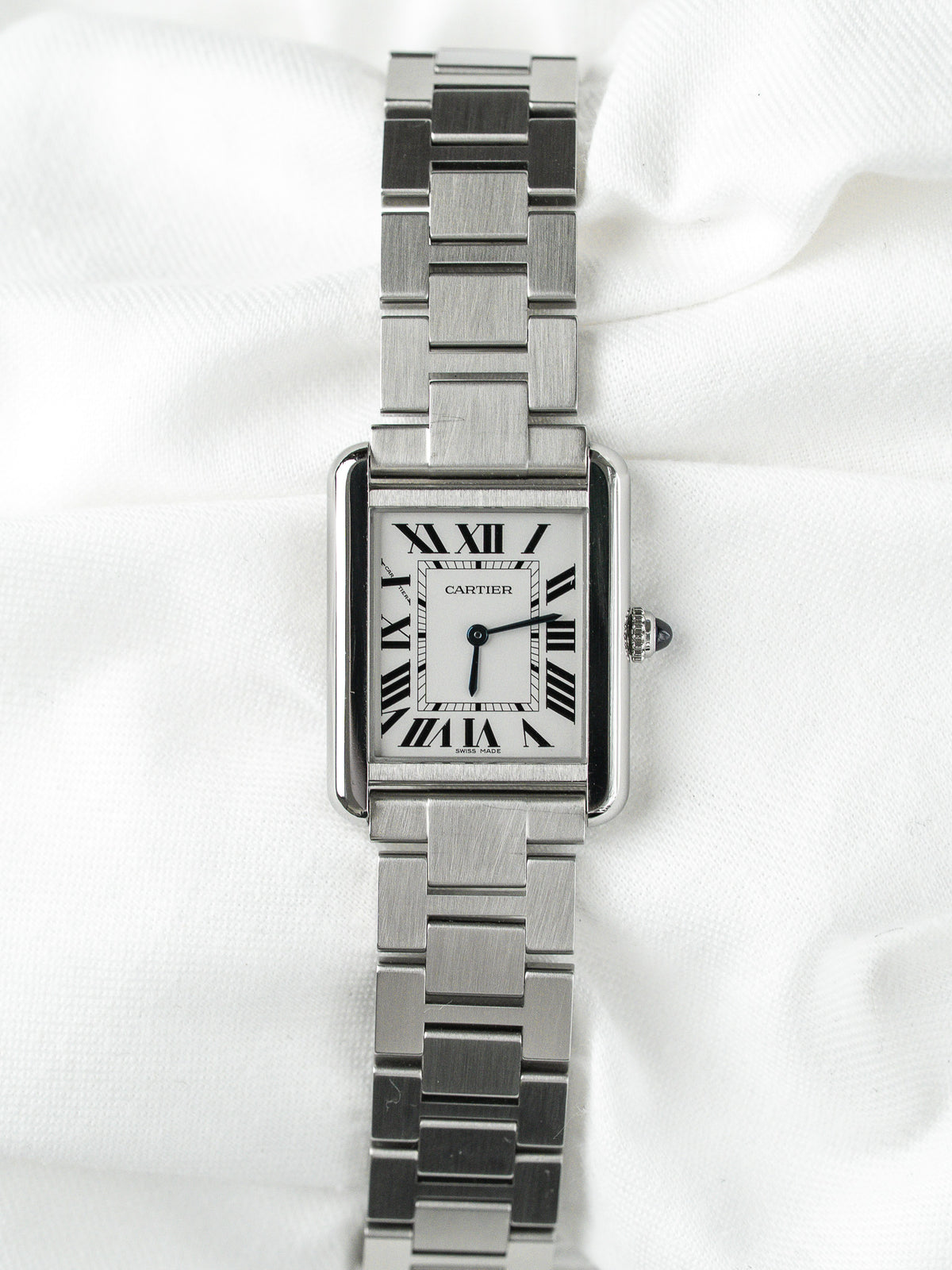 Montre Cartier Tank vintage en acier, boîtier rectangulaire et cadran blanc sur fond blanc