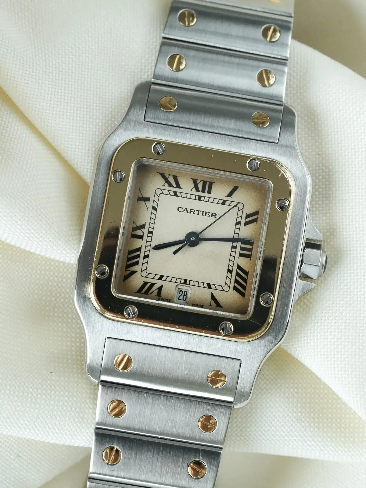 Cartier Santos vintage watch with steel case, cream dial, Roman numerals, and gold screws