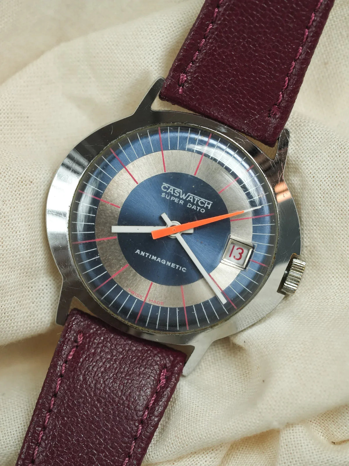 Caswatch Super Dato vintage watch with blue dial, orange second hand, burgundy leather strap