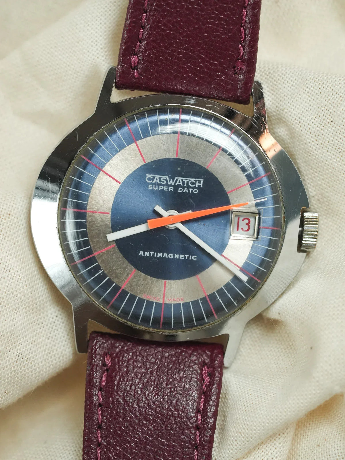 Caswatch Super Dato vintage watch with blue dial, orange second hand, burgundy leather strap