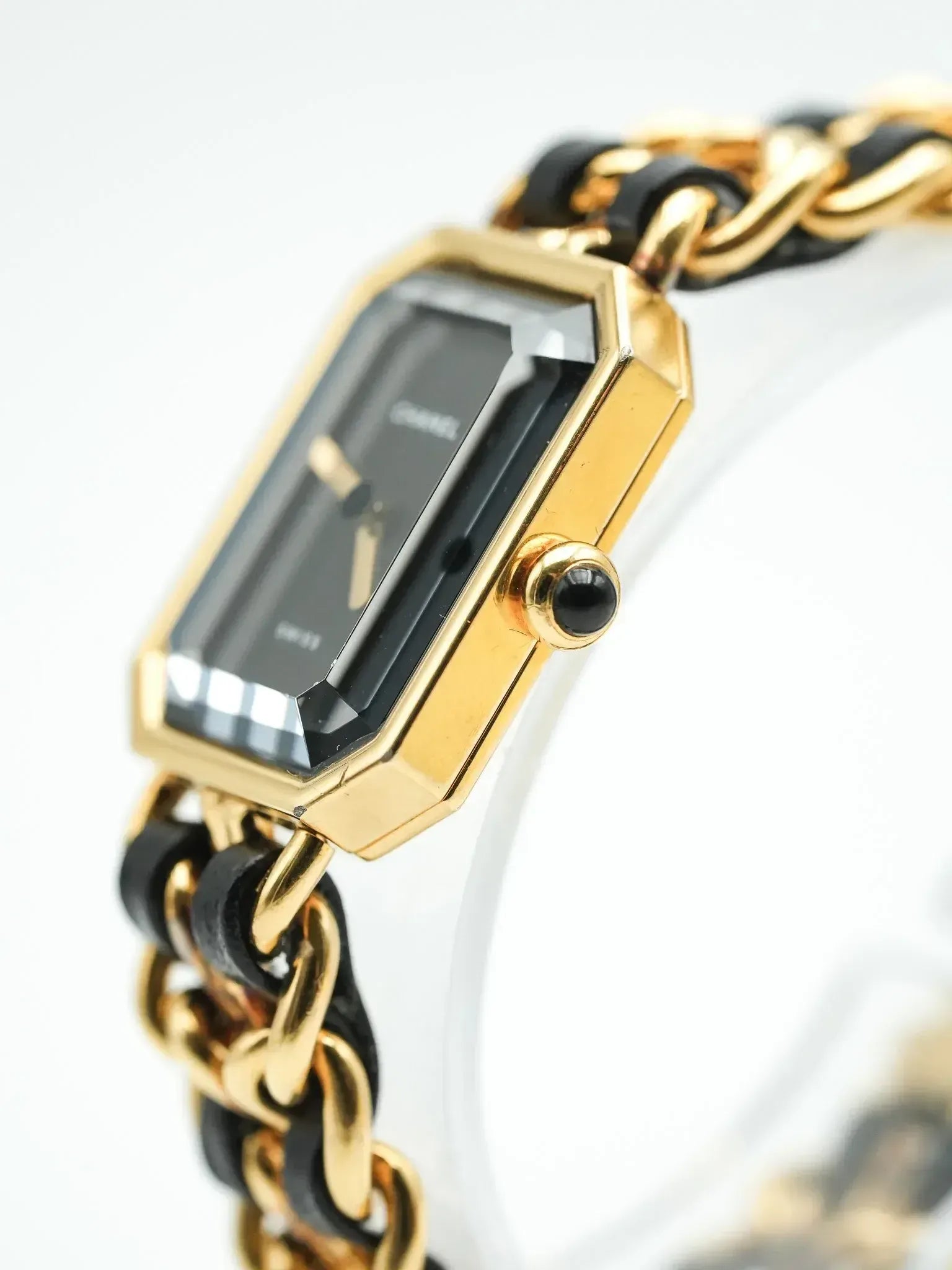 Cartier vintage watch with gold case, black dial, and chain bracelet