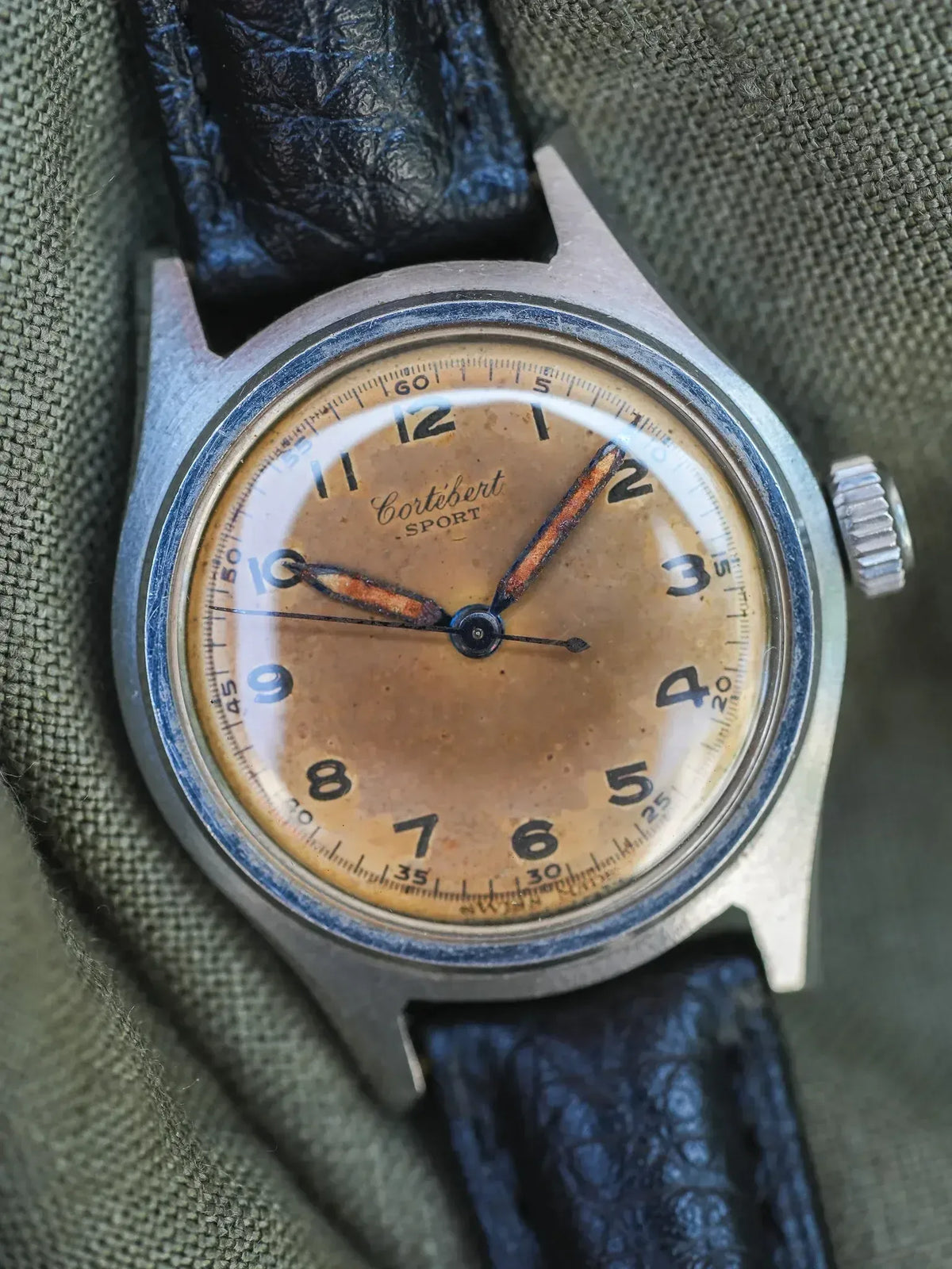 Cortébert Sport vintage watch with aged dial, steel case, and black leather strap