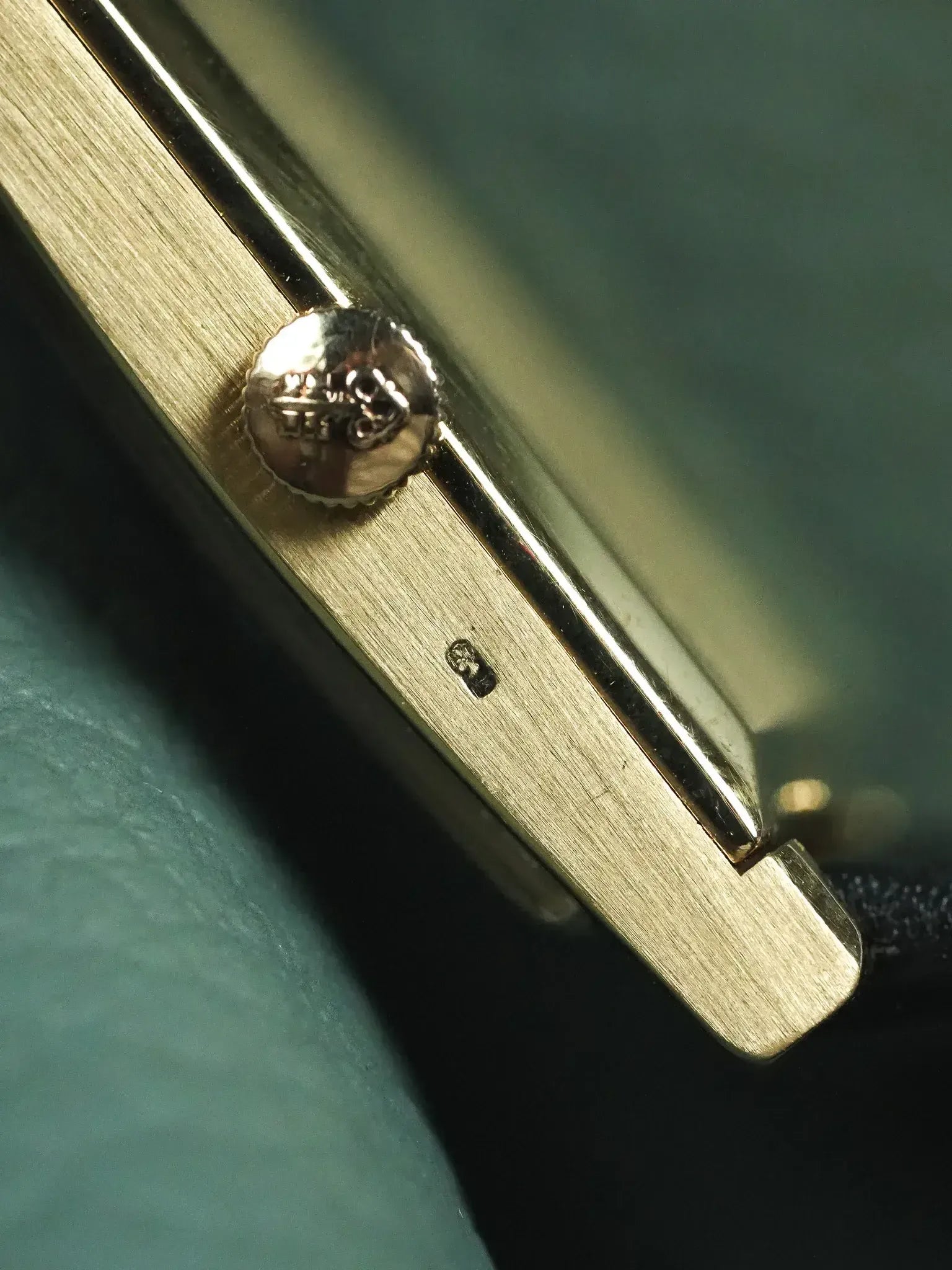 Vintage Cartier watch side view, gold case, crown with logo, brushed finish