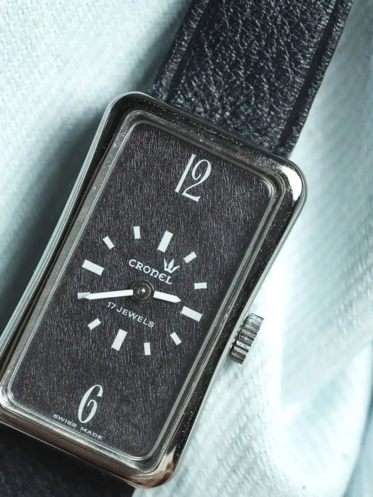 Cronel vintage watch with black textured dial, white markers, and black leather strap