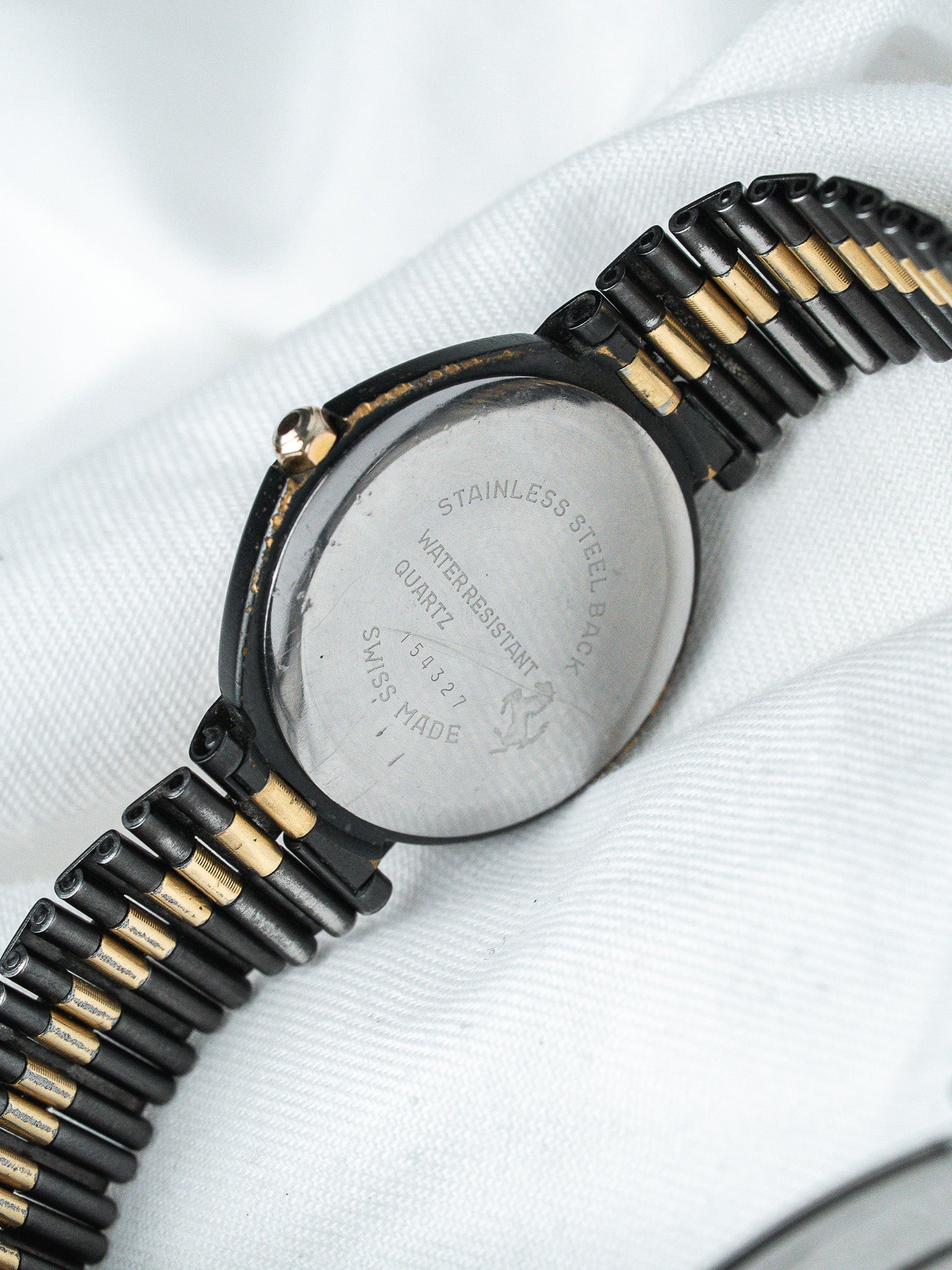 Vintage watch with stainless steel back, black and gold bracelet, Swiss made