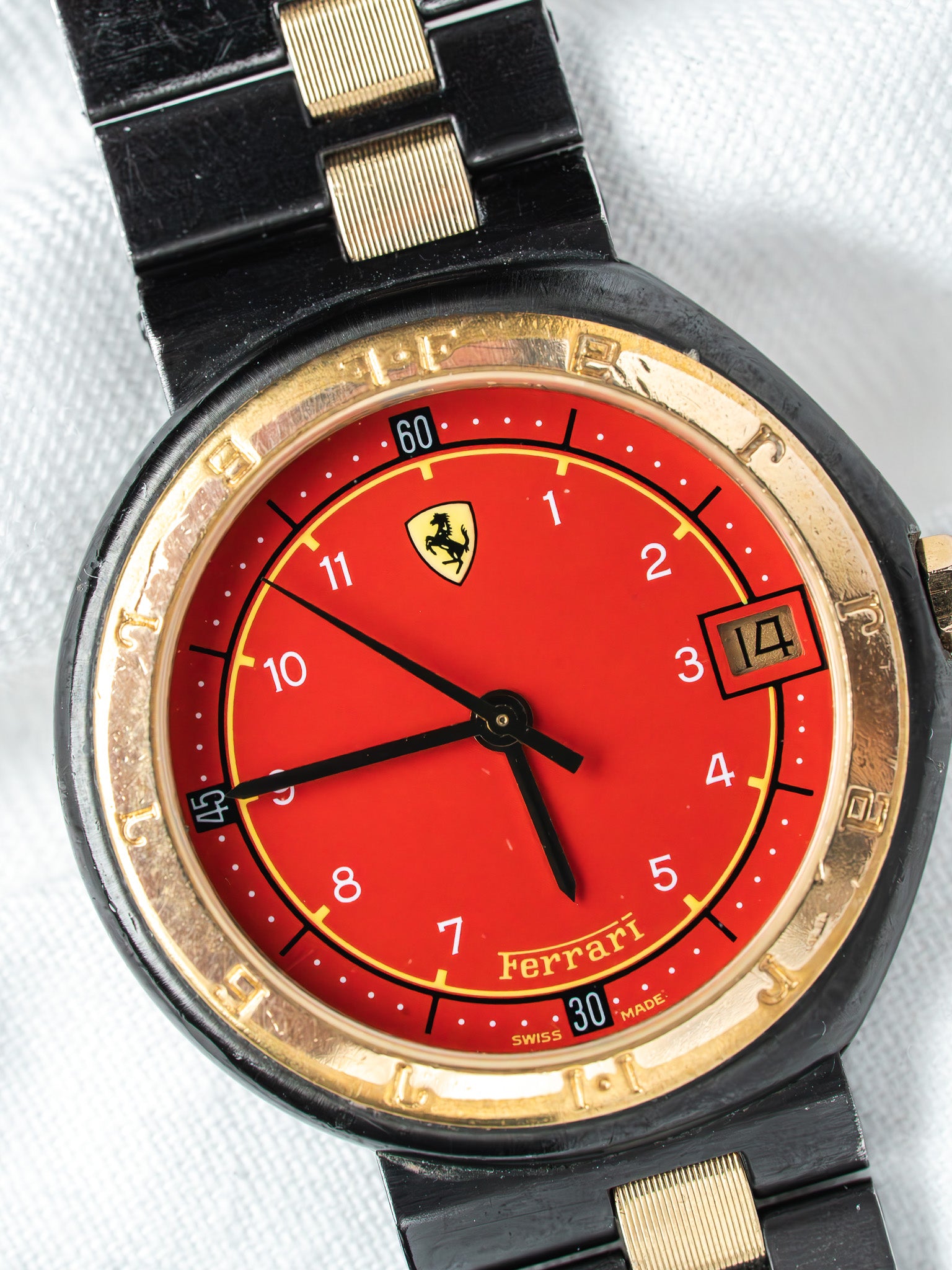 Ferrari vintage watch with red dial, gold accents, and black bracelet