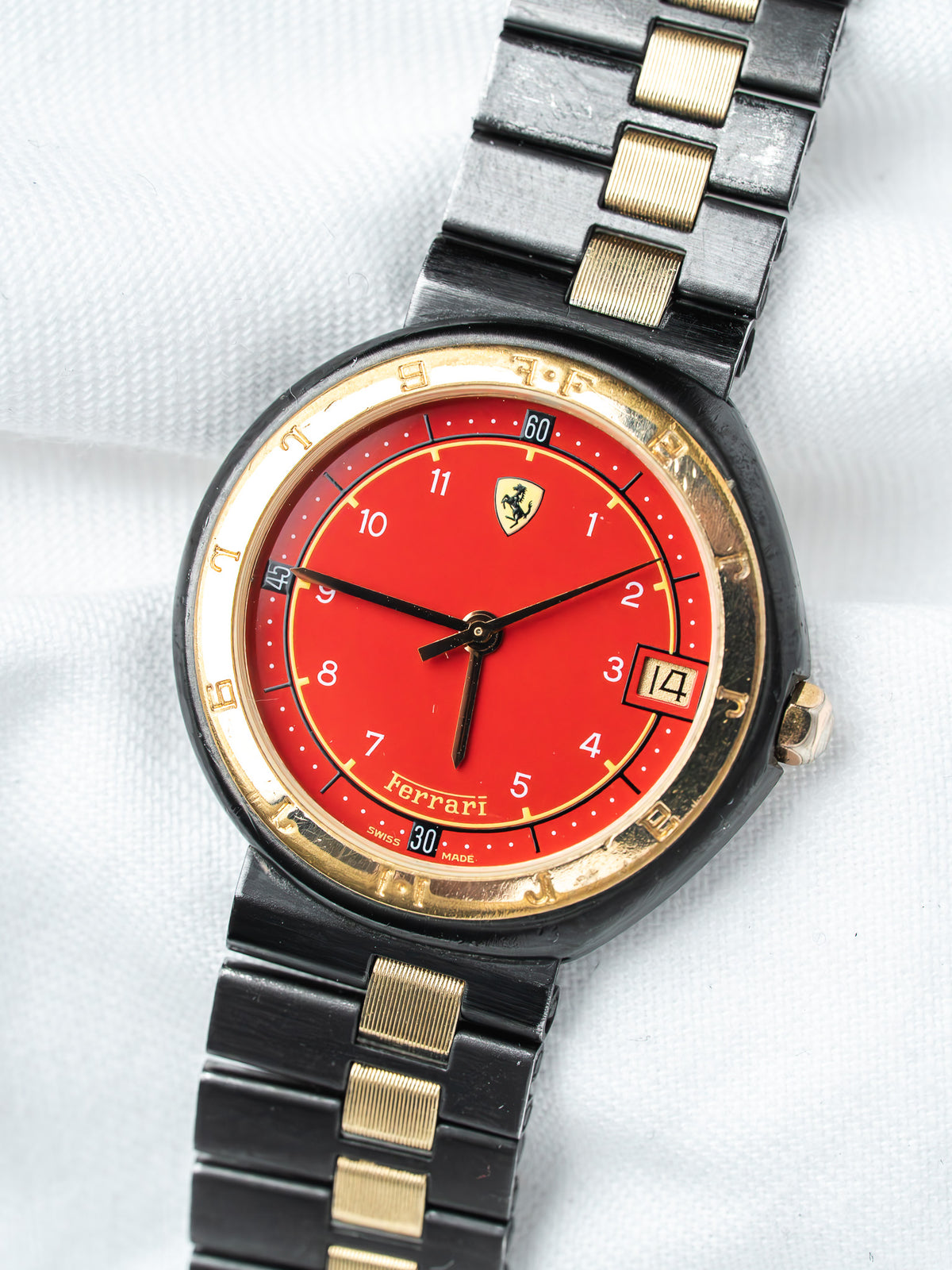 Ferrari watch with red dial, gold accents, black and gold bracelet