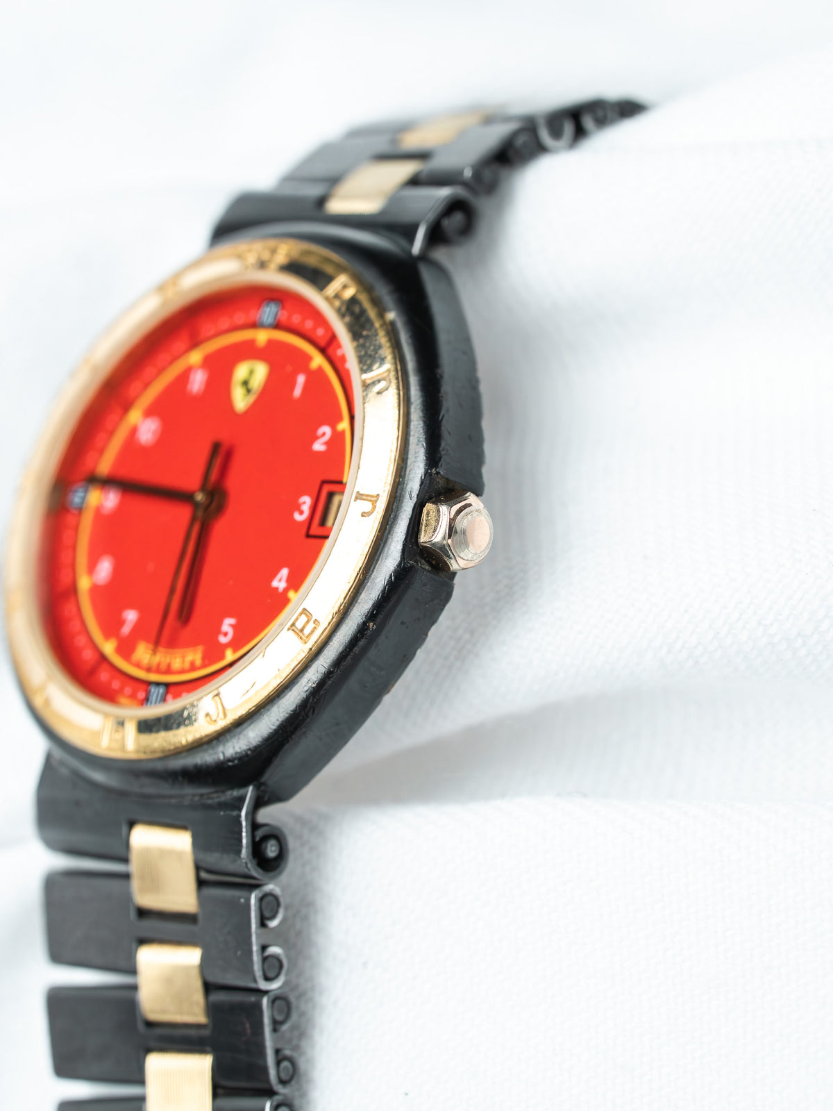 Ferrari vintage watch with red dial, gold bezel, black and gold bracelet