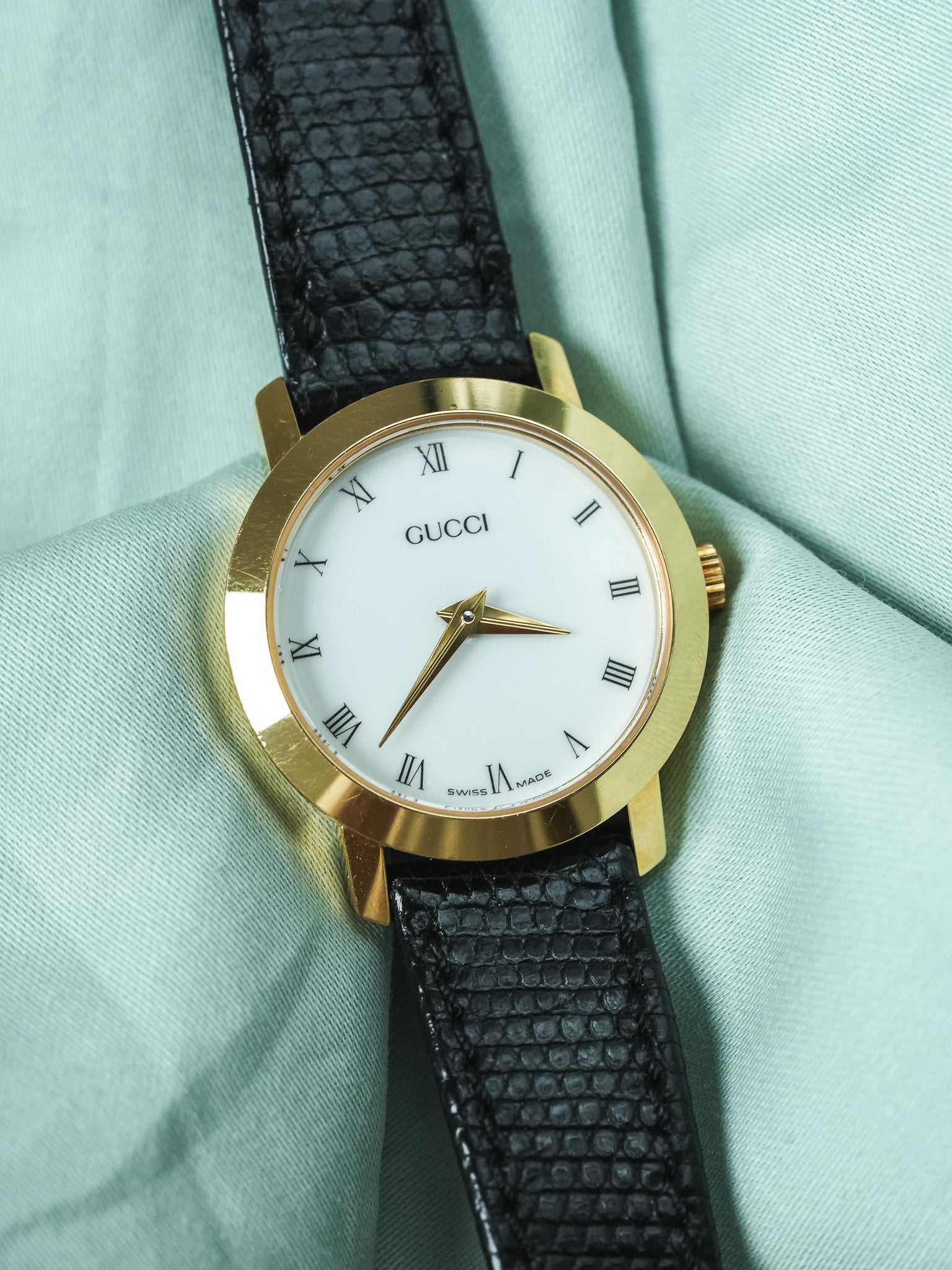 Gucci vintage watch with gold case, white dial, Roman numerals, black lizard strap