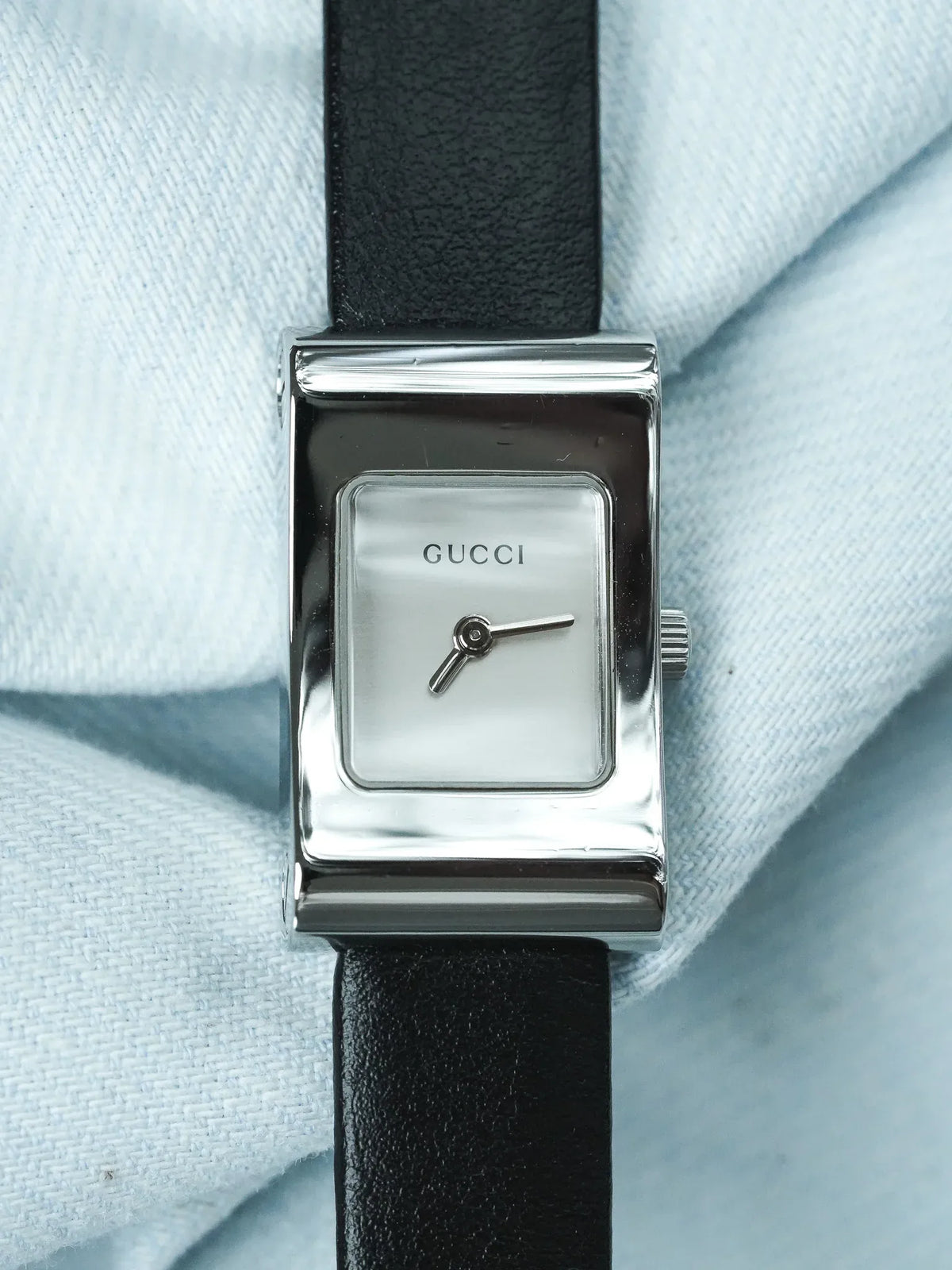 Gucci vintage watch with rectangular silver case, mother-of-pearl dial, black leather strap