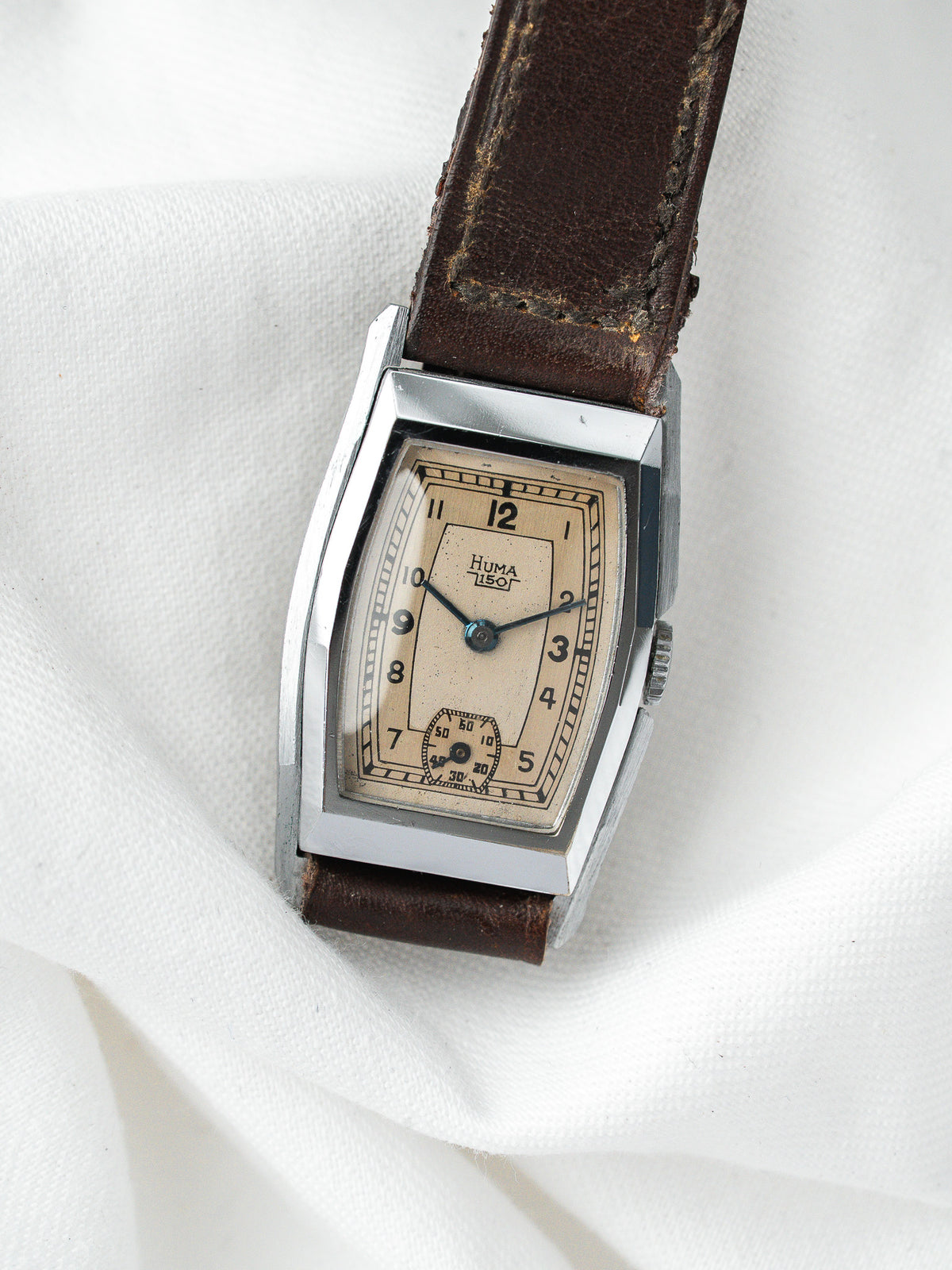 Montre Huma vintage, boîtier rectangulaire argenté, cadran crème et bracelet cuir marron