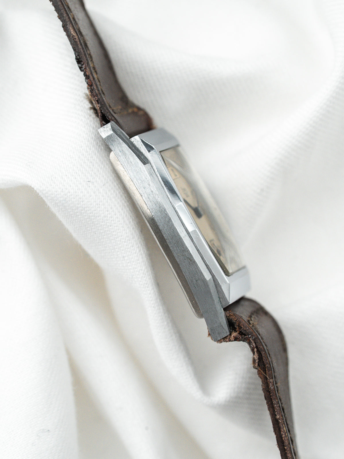 Montre vintage au boîtier rectangulaire en acier avec un bracelet en cuir brun