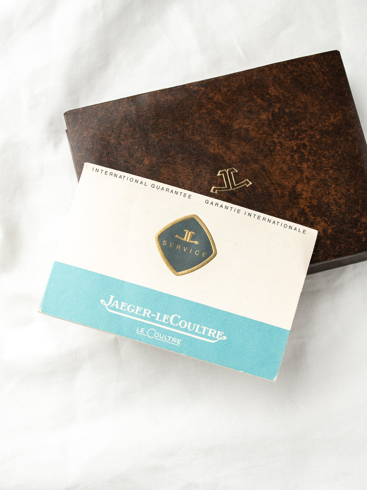 Internationale Garantie und Vintage Jaeger-LeCoultre Box auf weißem Hintergrund