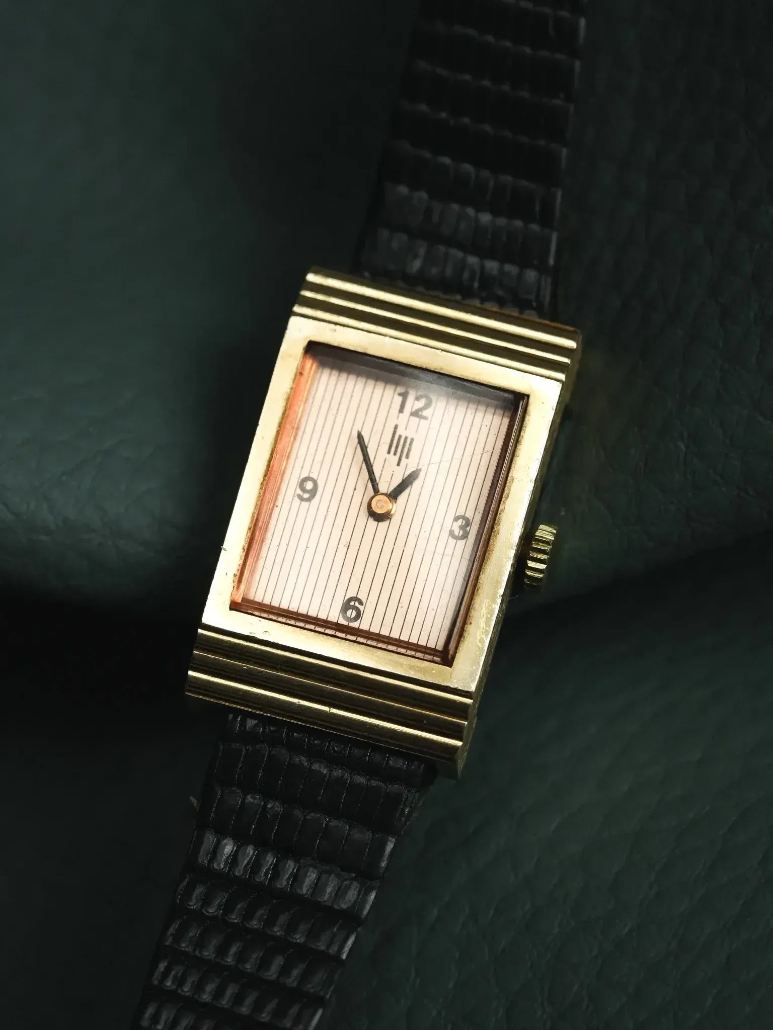 Vintage rectangular gold watch with striped dial and black leather strap
