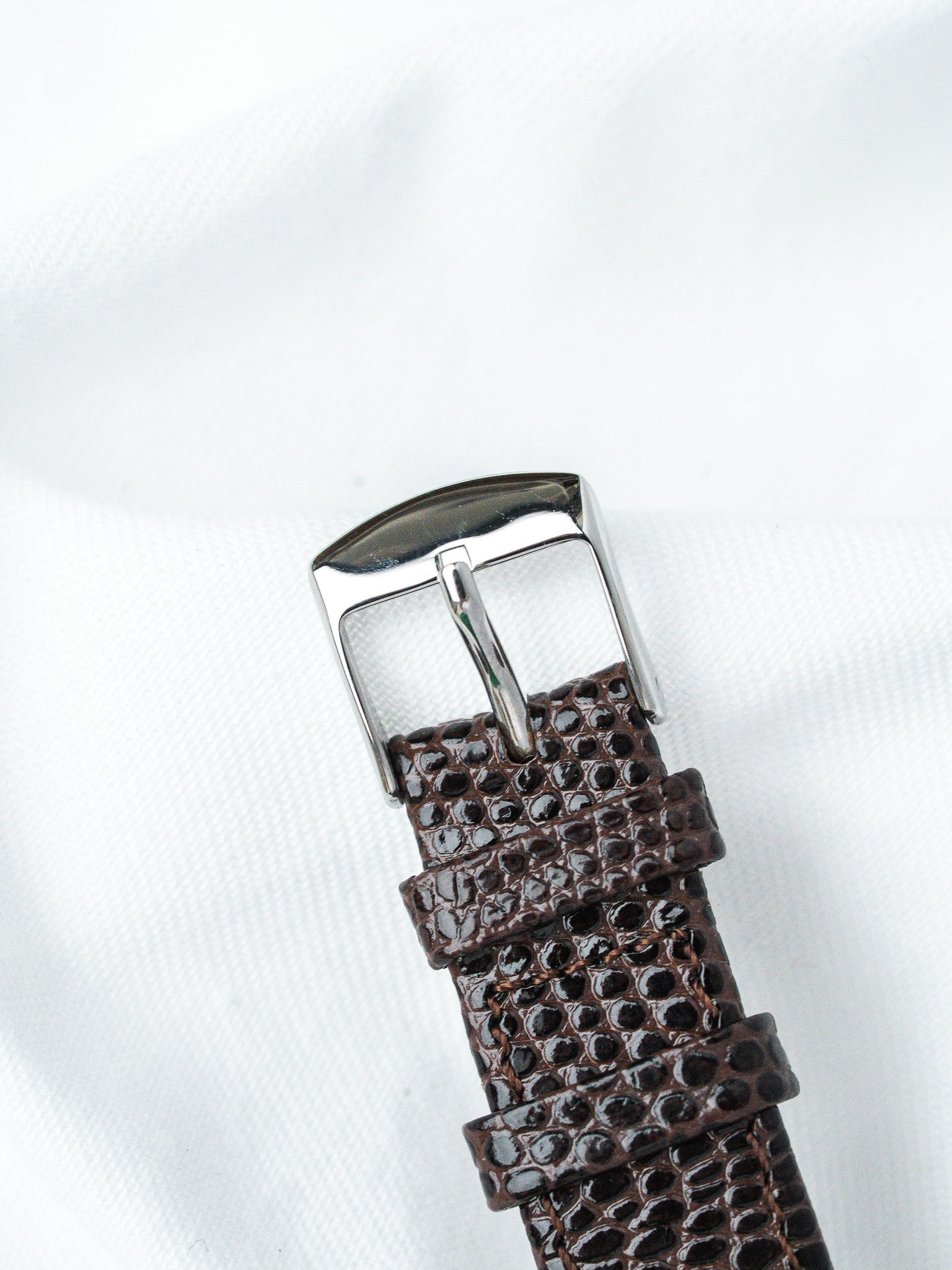 Brown textured leather watch strap with polished silver buckle