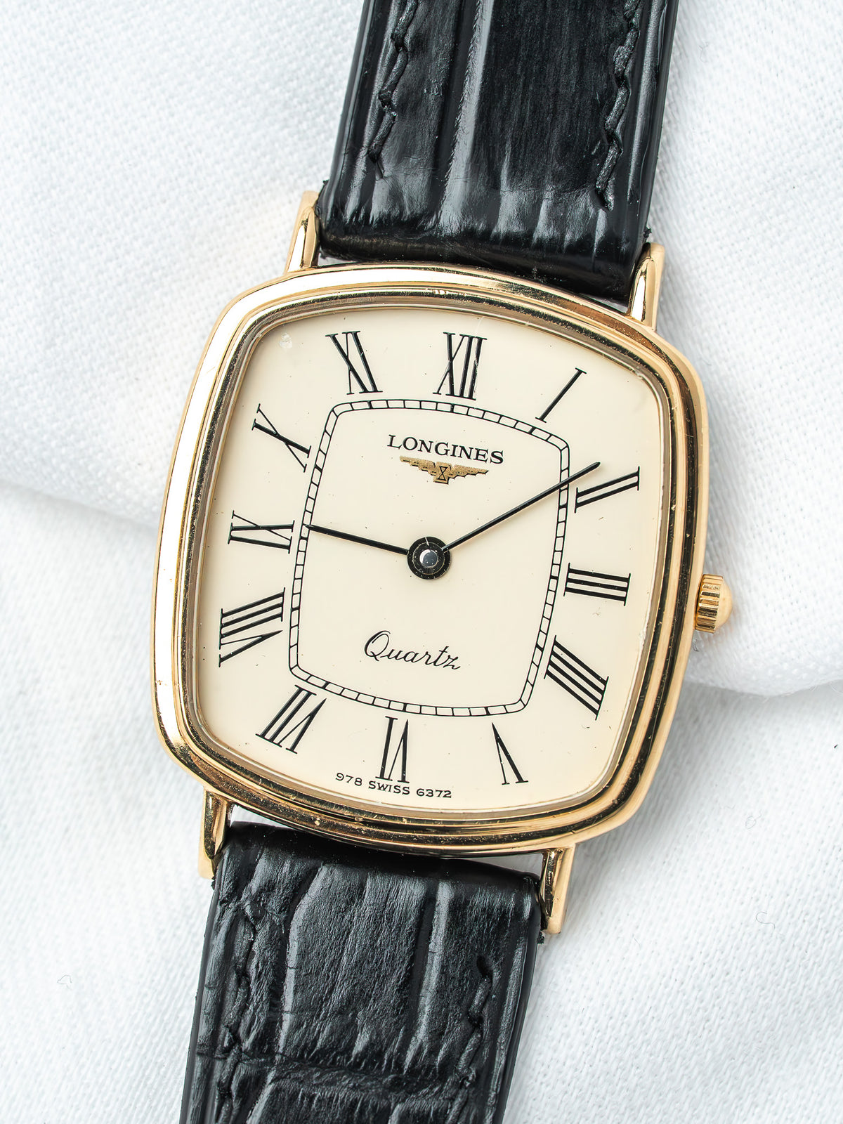 Longines vintage quartz watch with gold case, cream dial, Roman numerals, black leather strap