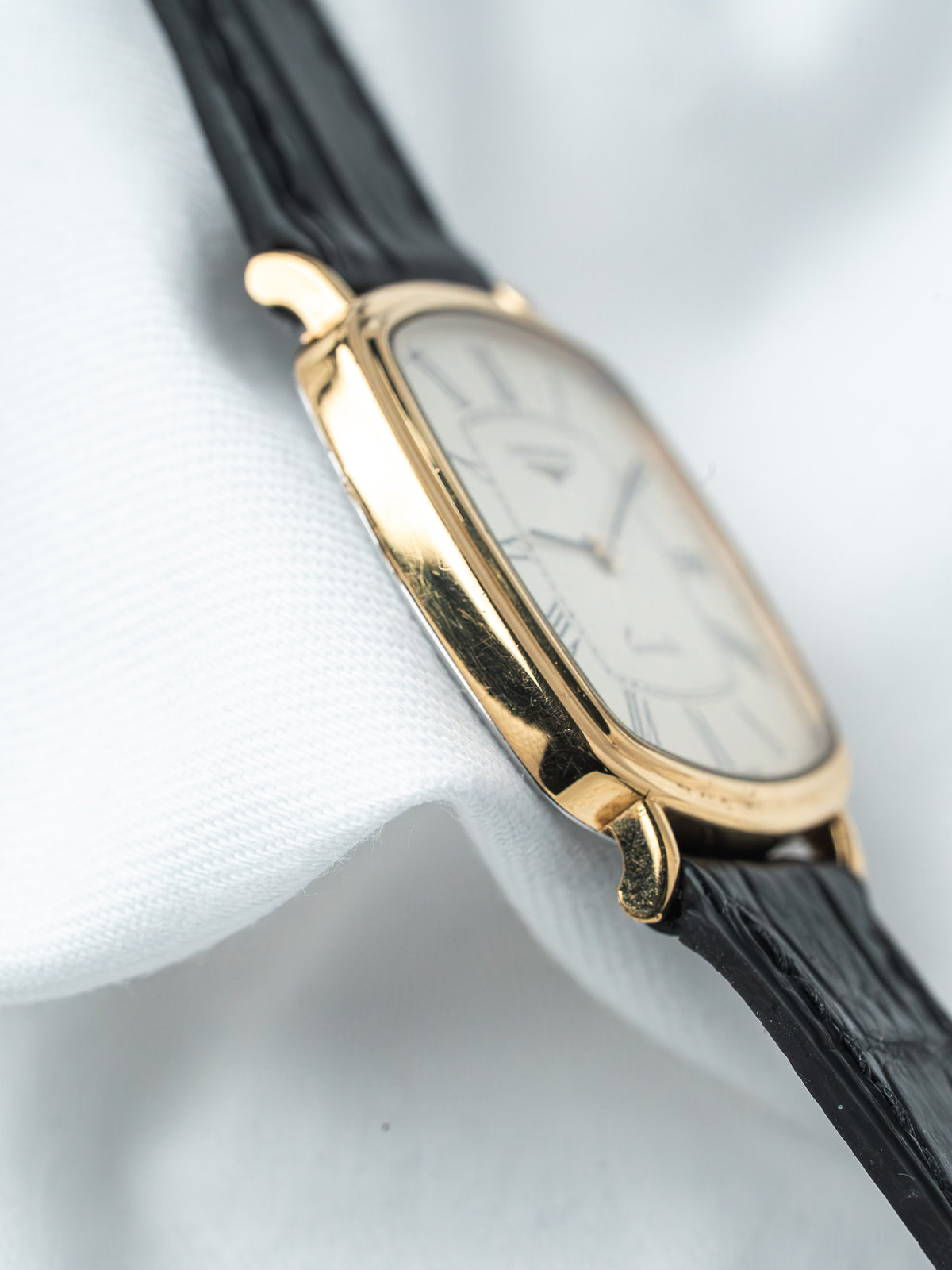 Vintage Cartier watch with gold case, white dial, black leather strap