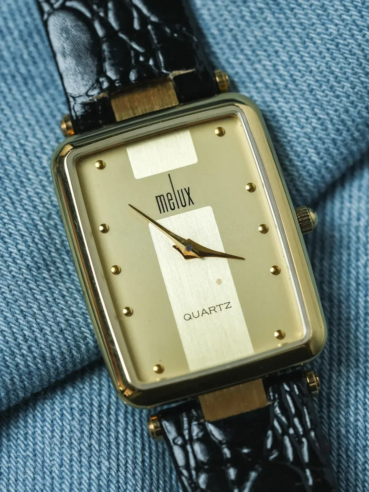 Melux vintage quartz watch with gold case, cream dial, and black crocodile strap