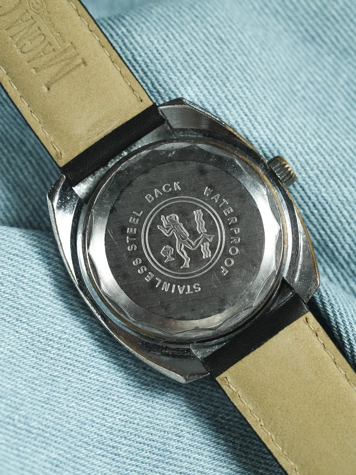 Vintage Omega Seamaster stainless steel back with diver emblem, tan leather strap
