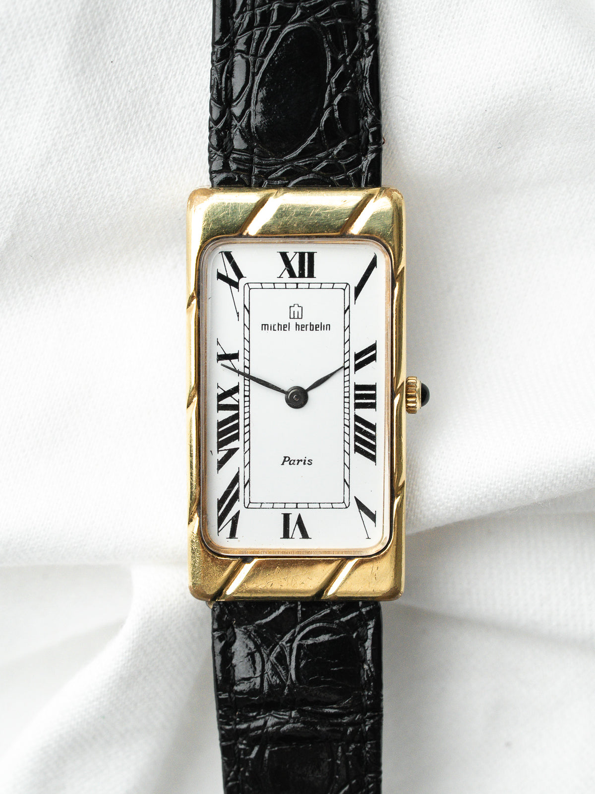 Montre Michel Herbelin vintage, boîtier rectangulaire plaqué or, cadran blanc et bracelet cuir noir