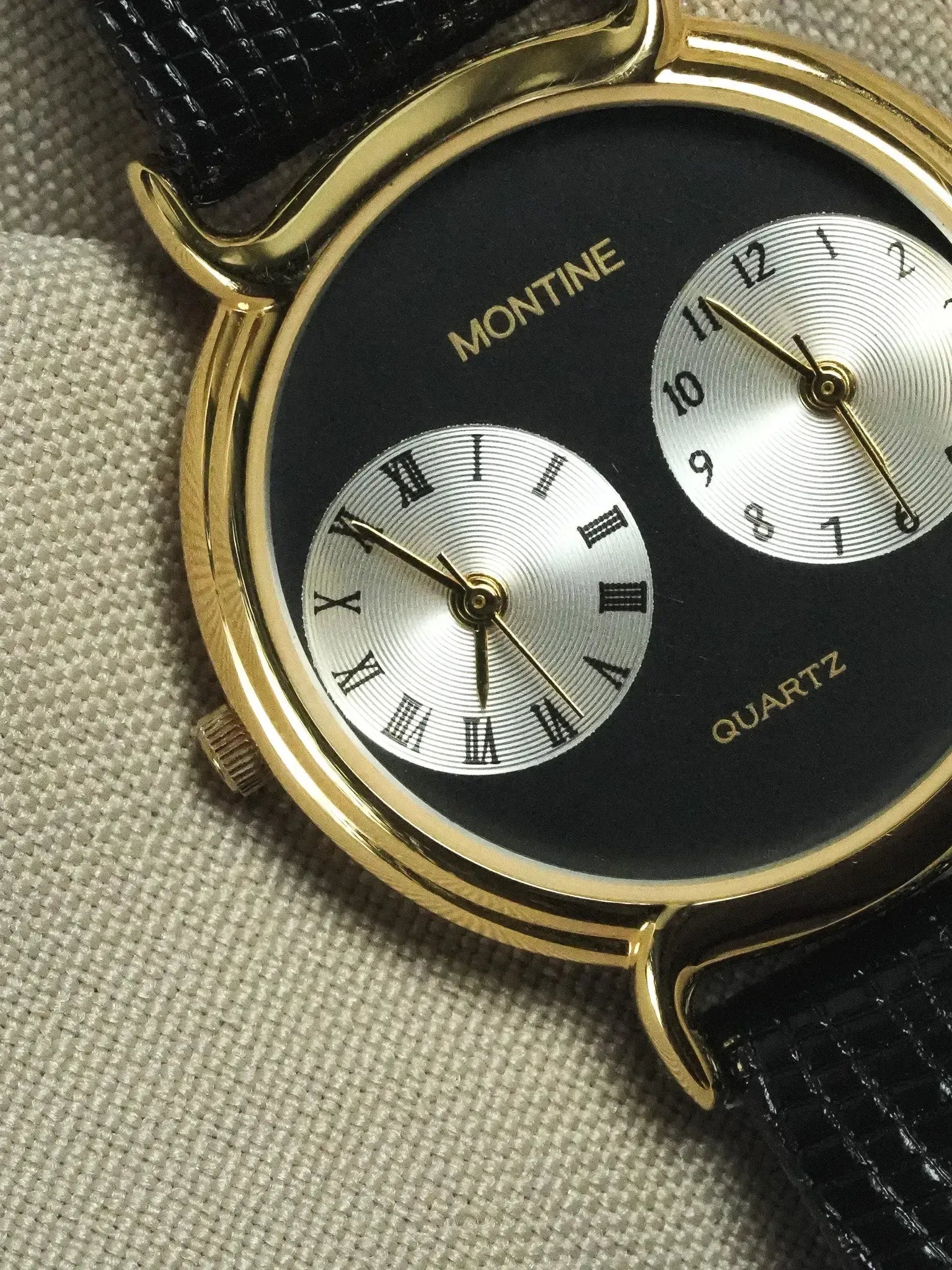 Montine vintage quartz watch with gold case, black dial, Roman numerals, and black leather strap