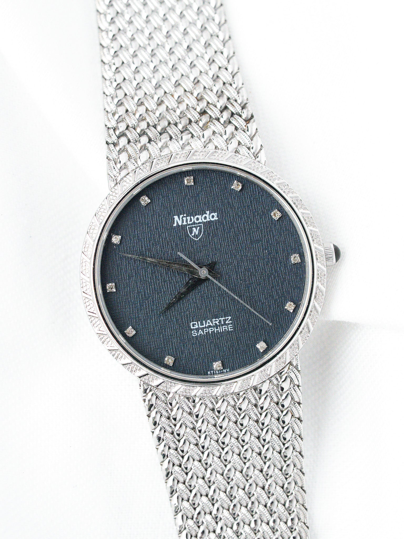 Nivada vintage watch with blue dial, diamond markers, and mesh bracelet on white background