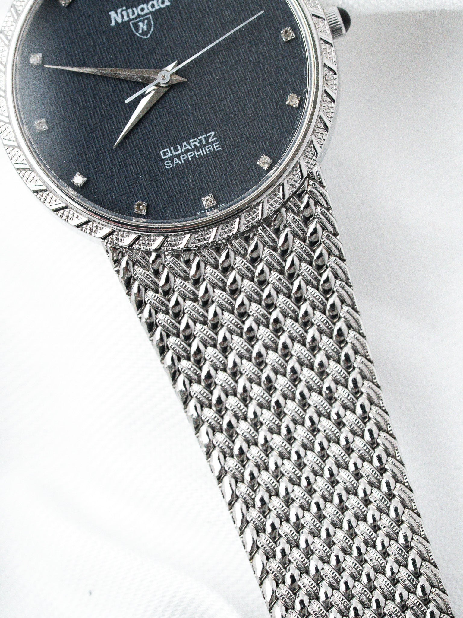 Nivada vintage watch with black dial, diamond markers, and textured metal bracelet