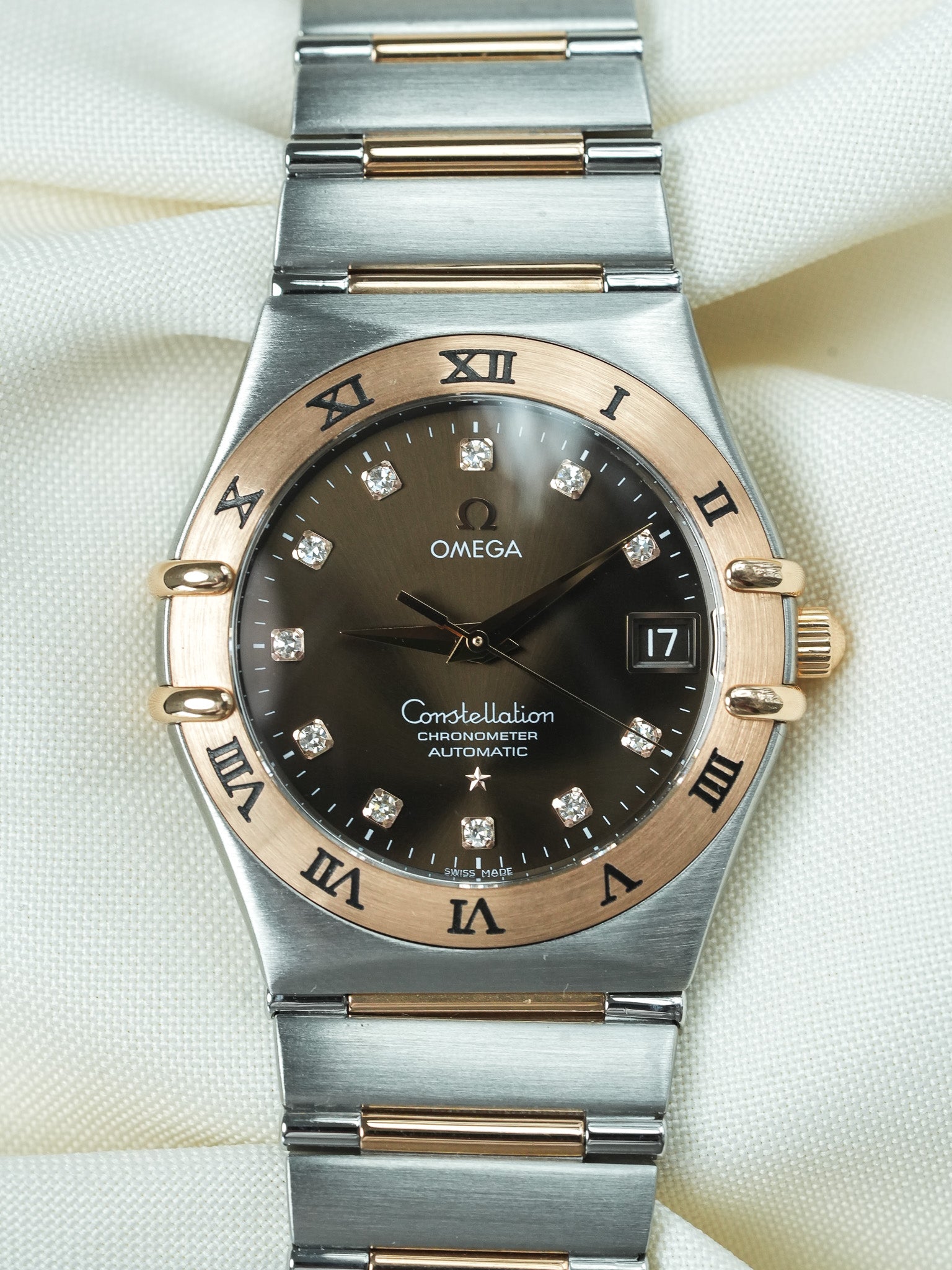Omega Constellation automatic watch with black dial, diamond markers, and two-tone steel and gold bracelet