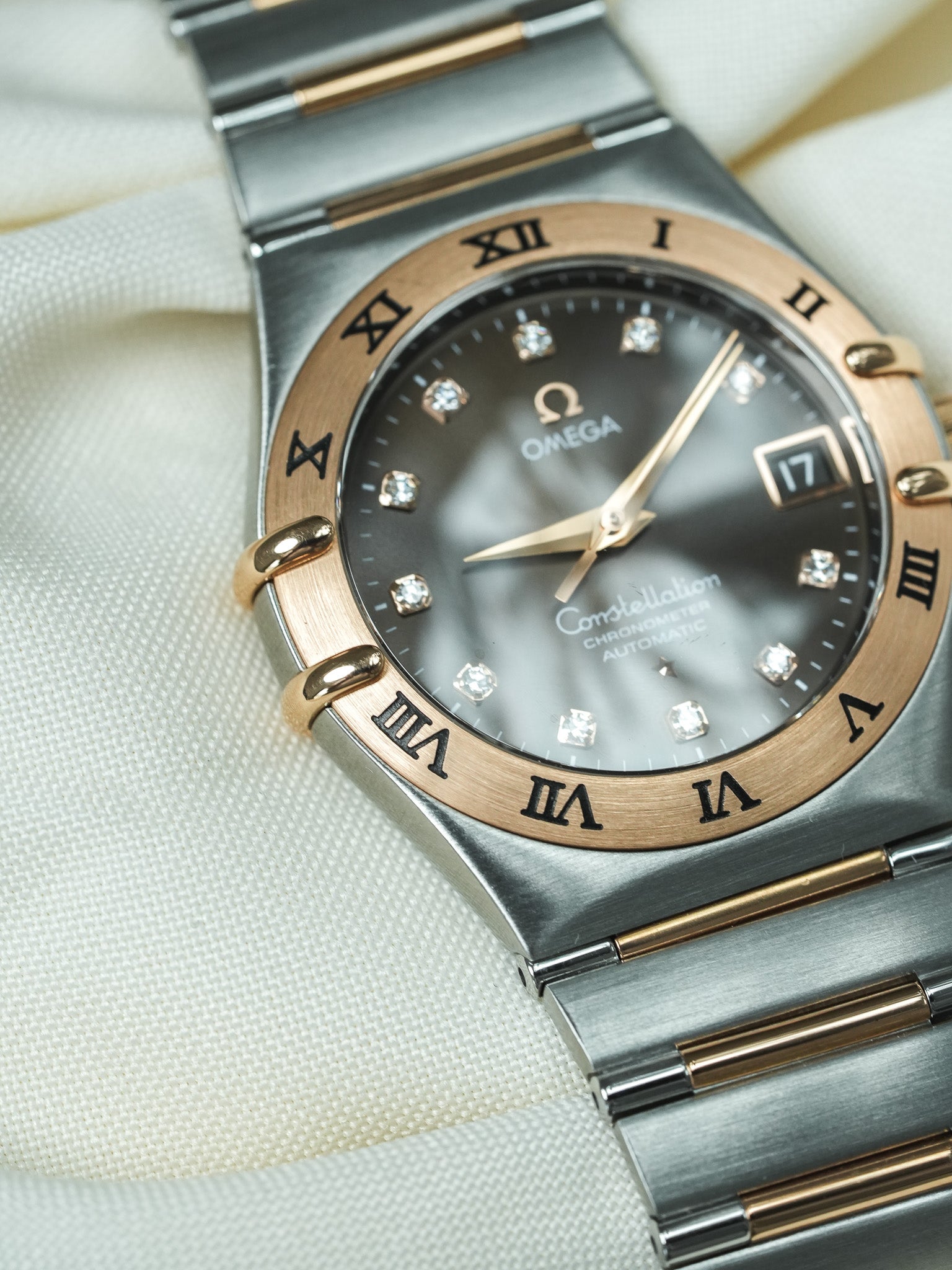 Omega Constellation automatic watch with diamond hour markers, black dial, and two-tone bracelet