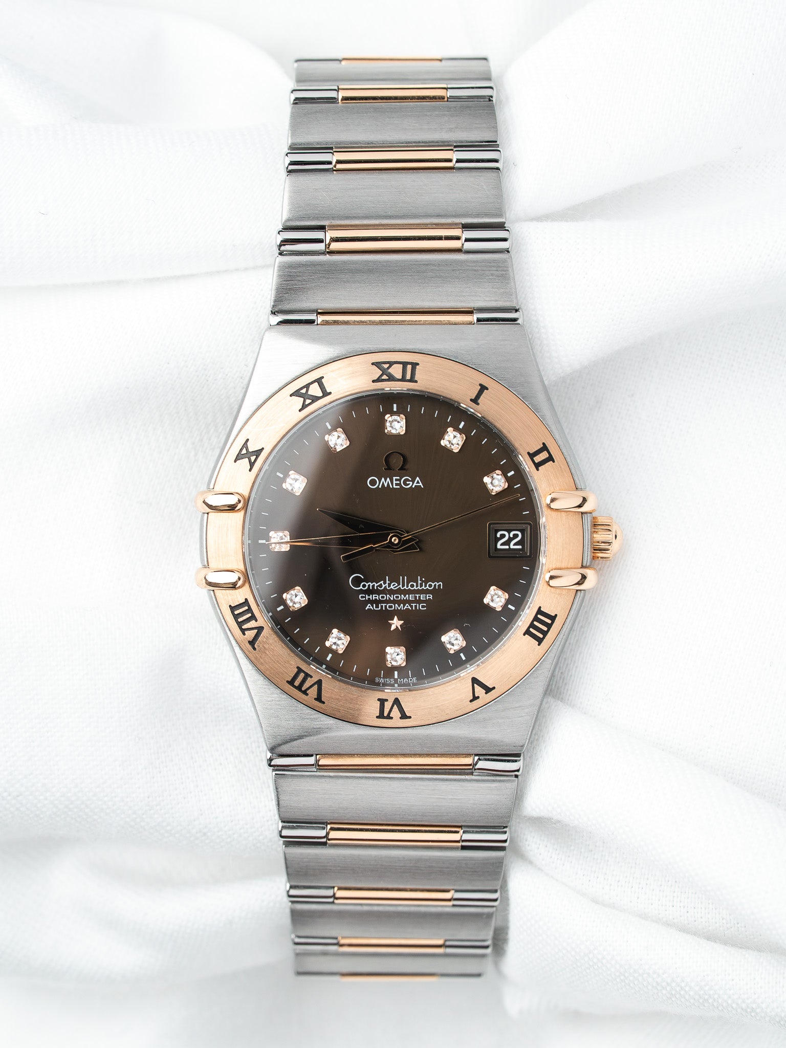 Omega Constellation watch with brown dial, diamond markers, and two-tone steel and rose gold bracelet